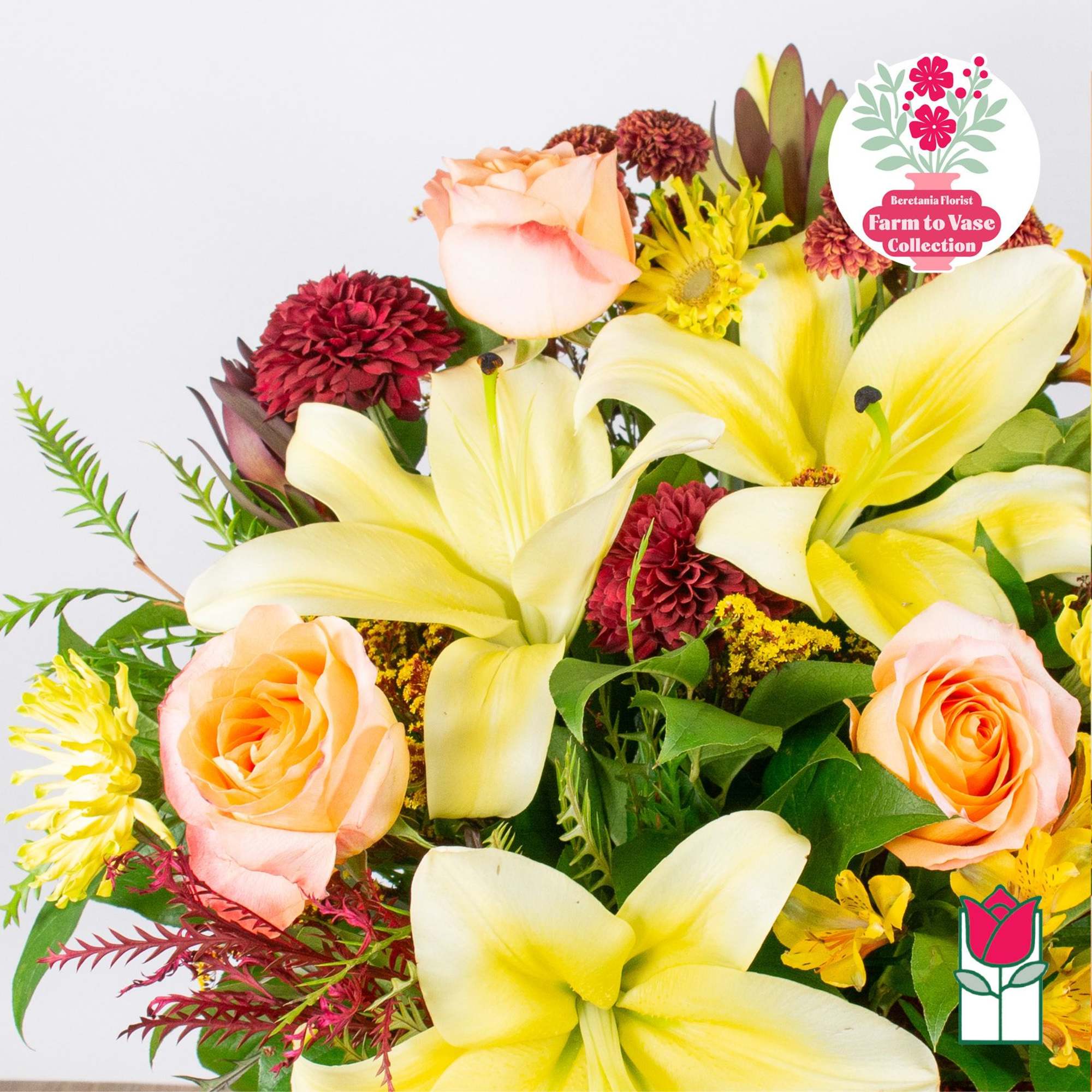 Bouquet of yellow lilies and peach roses with burgundy mums