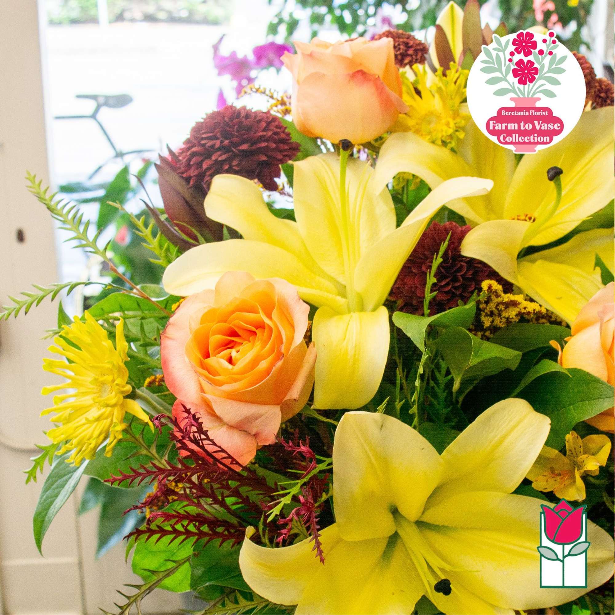 Bouquet of yellow lilies and peach roses with burgundy blooms