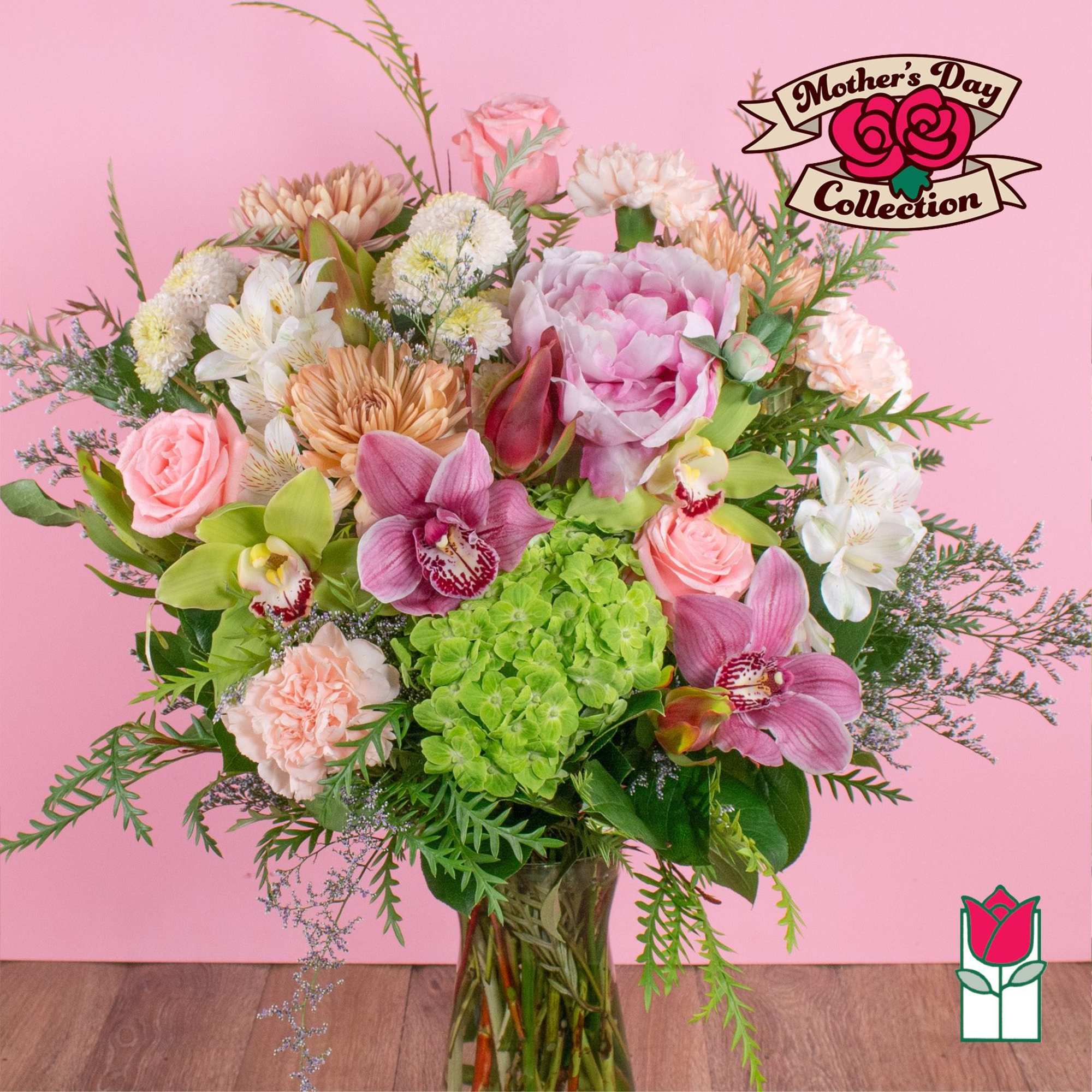 Mixed bouquet of pink flowers, orchids, and green hydrangea in a clear glass vase