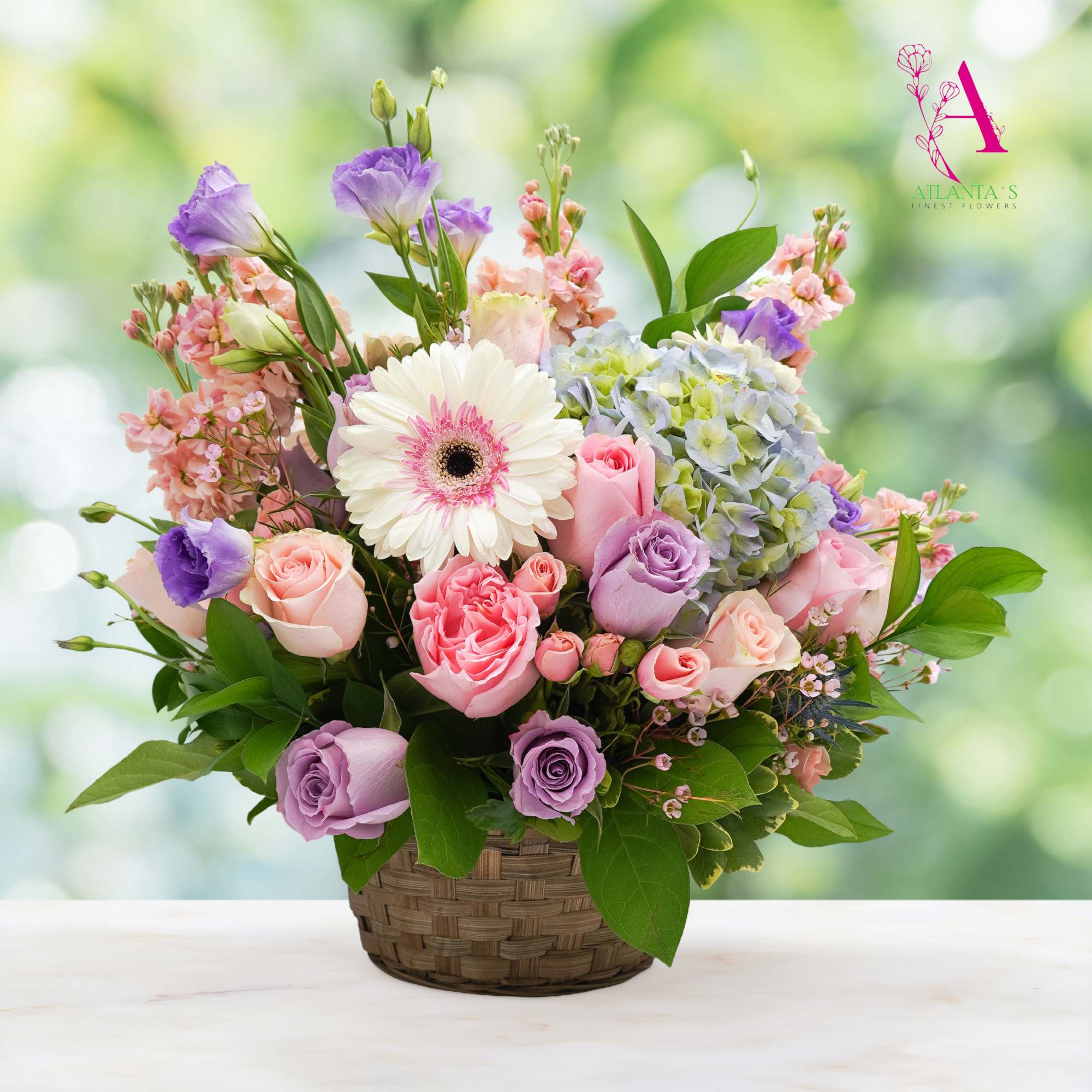 Pastel bouquet in a woven basket with roses, hydrangea, and a white gerbera daisy