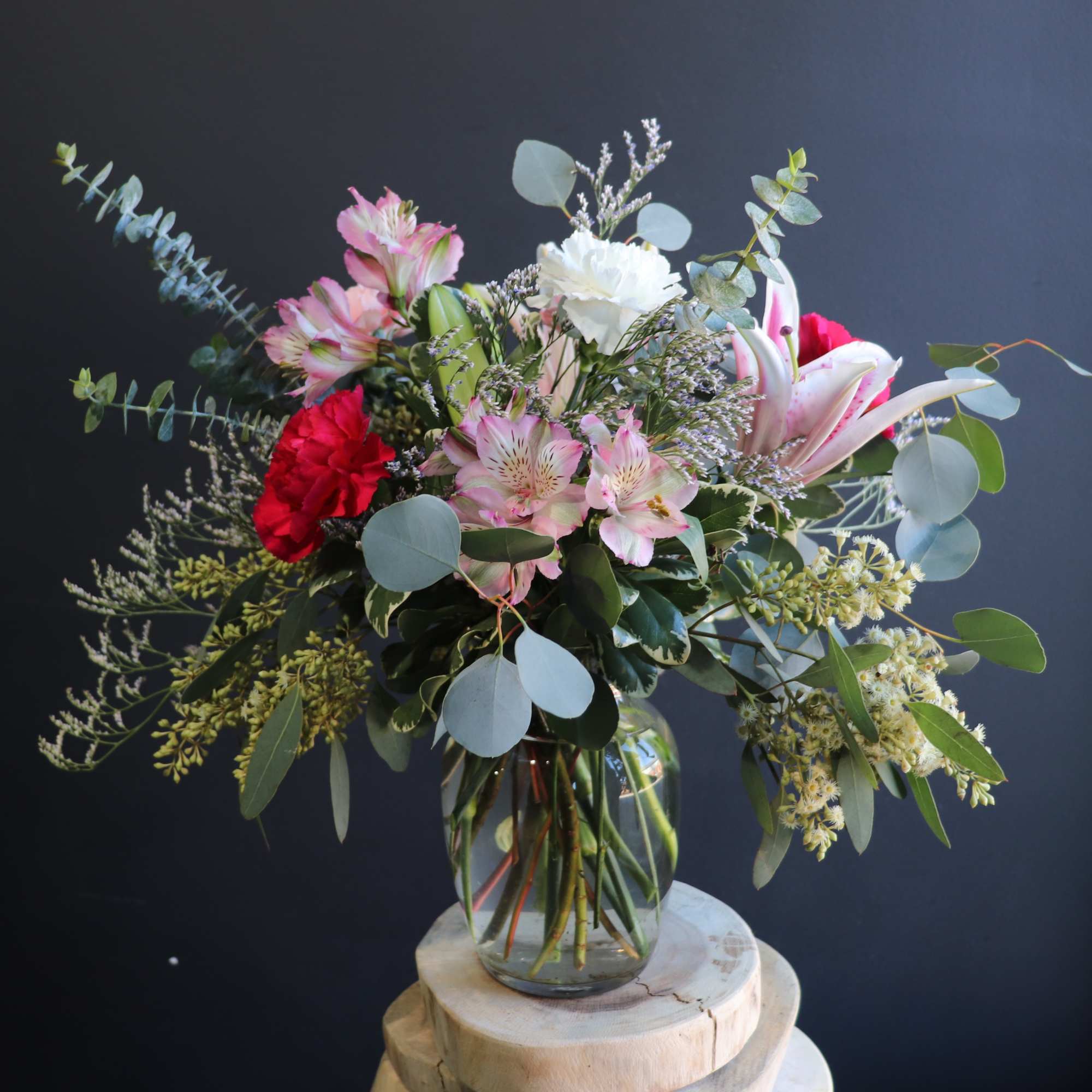 A lush airy arrangement with an abundance of greenery and a variety