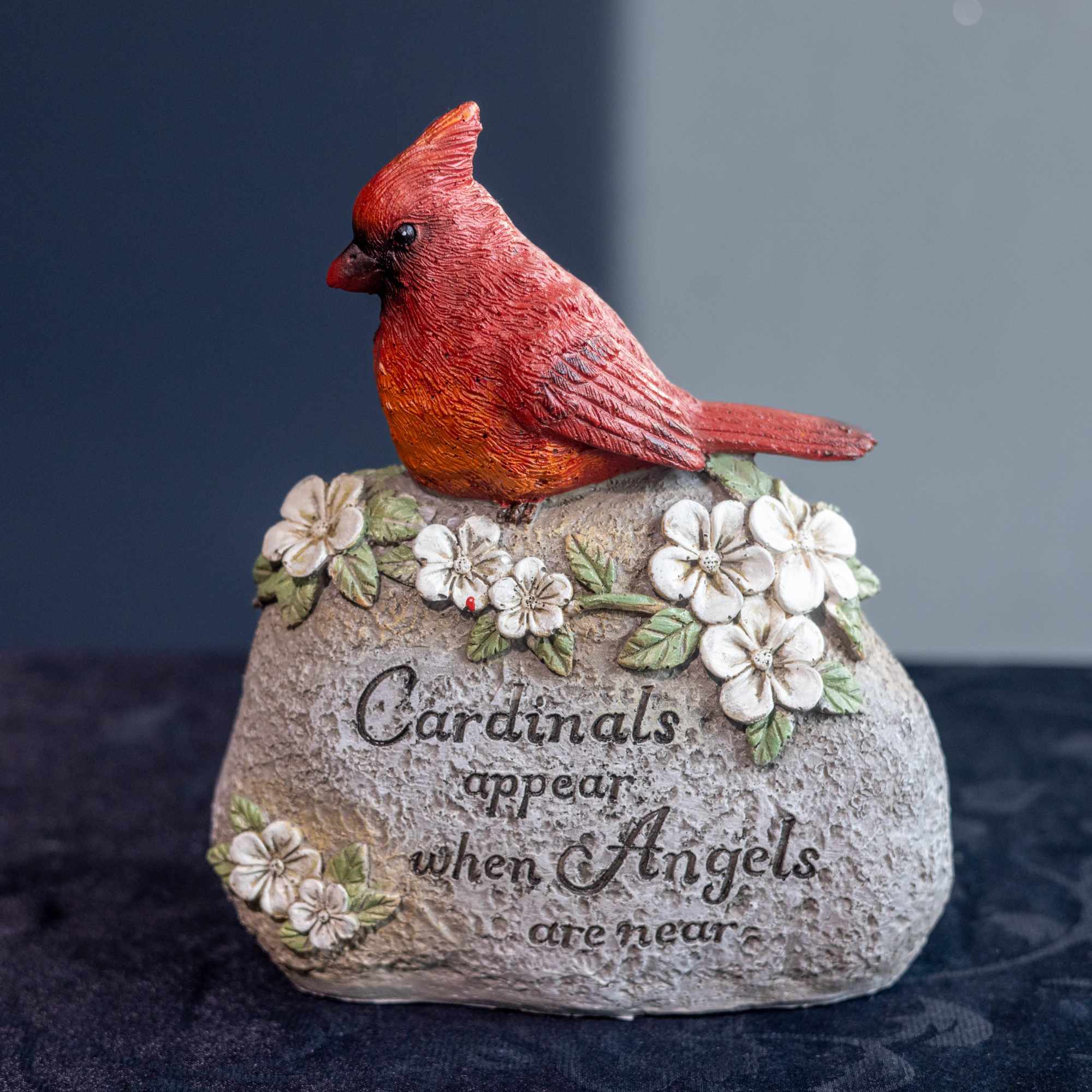 Cardinal figurine on a stone-look memorial plaque with flowers