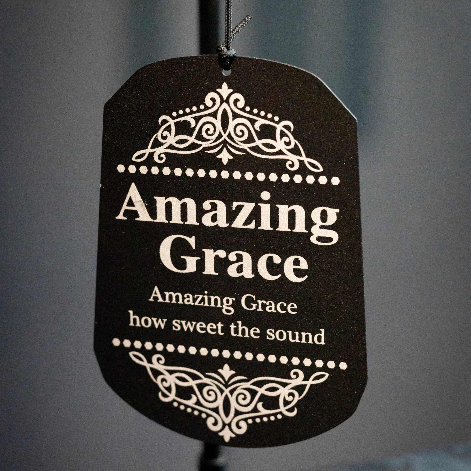 Black hanging tag with the words Amazing Grace in white text