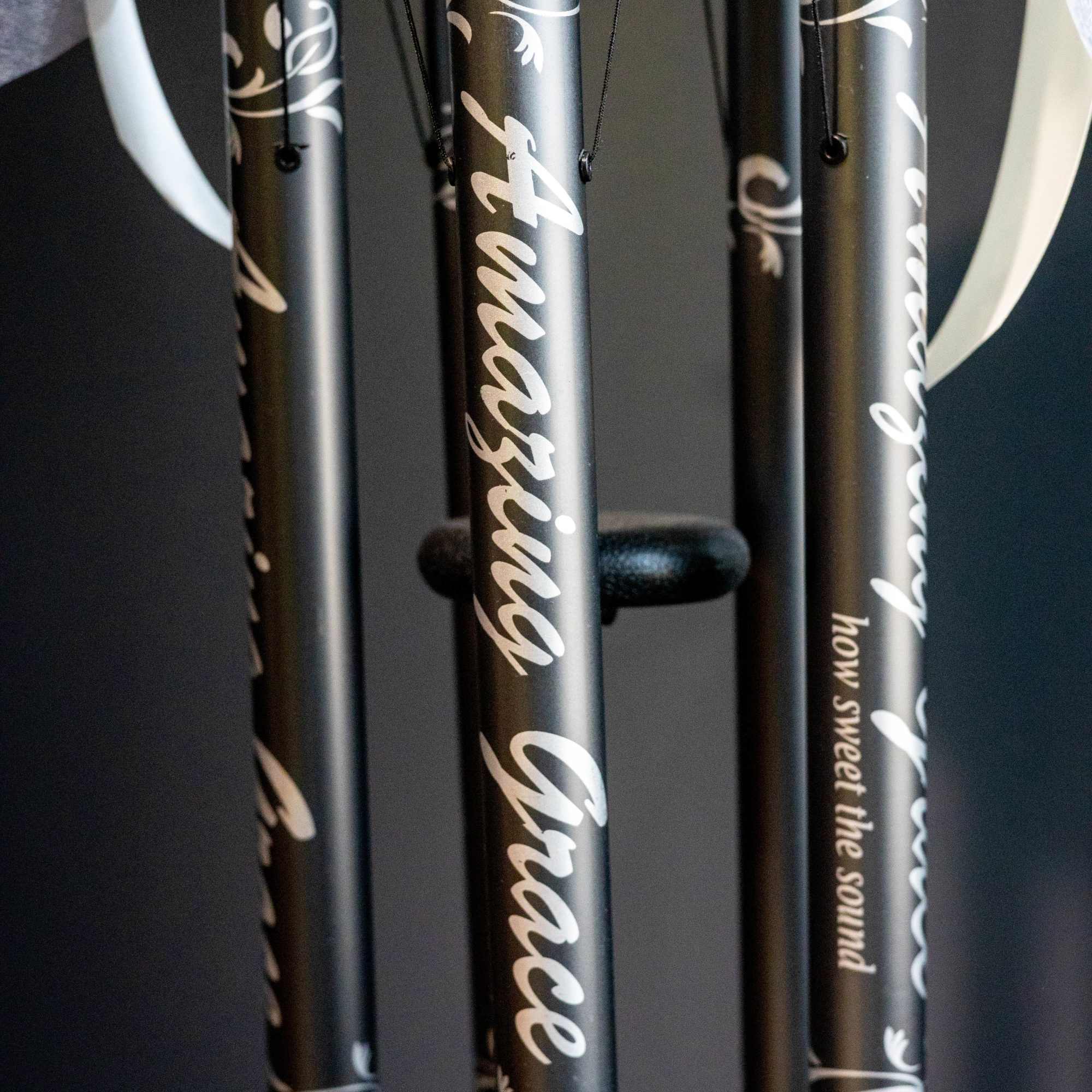 Black wind chimes with white script hanging indoors