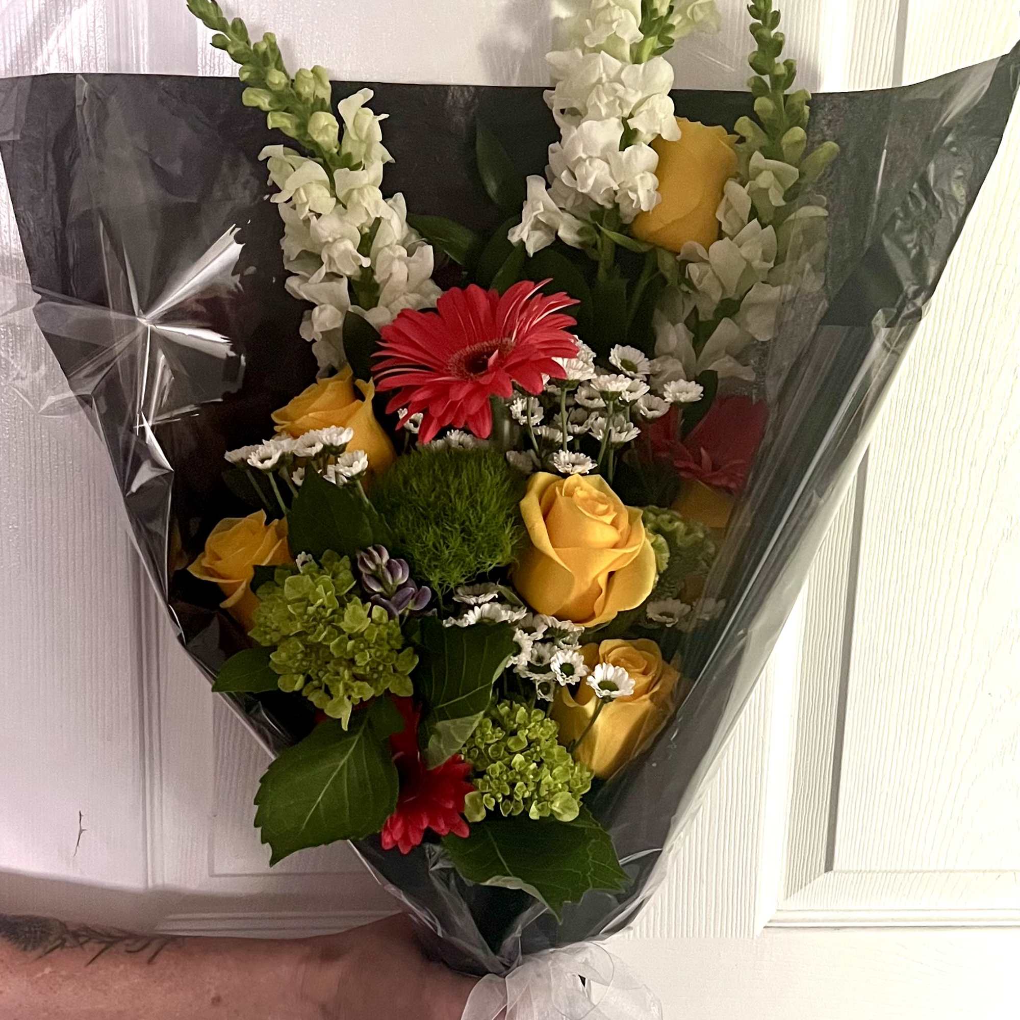 Bouquet of yellow and red flowers wrapped in black paper