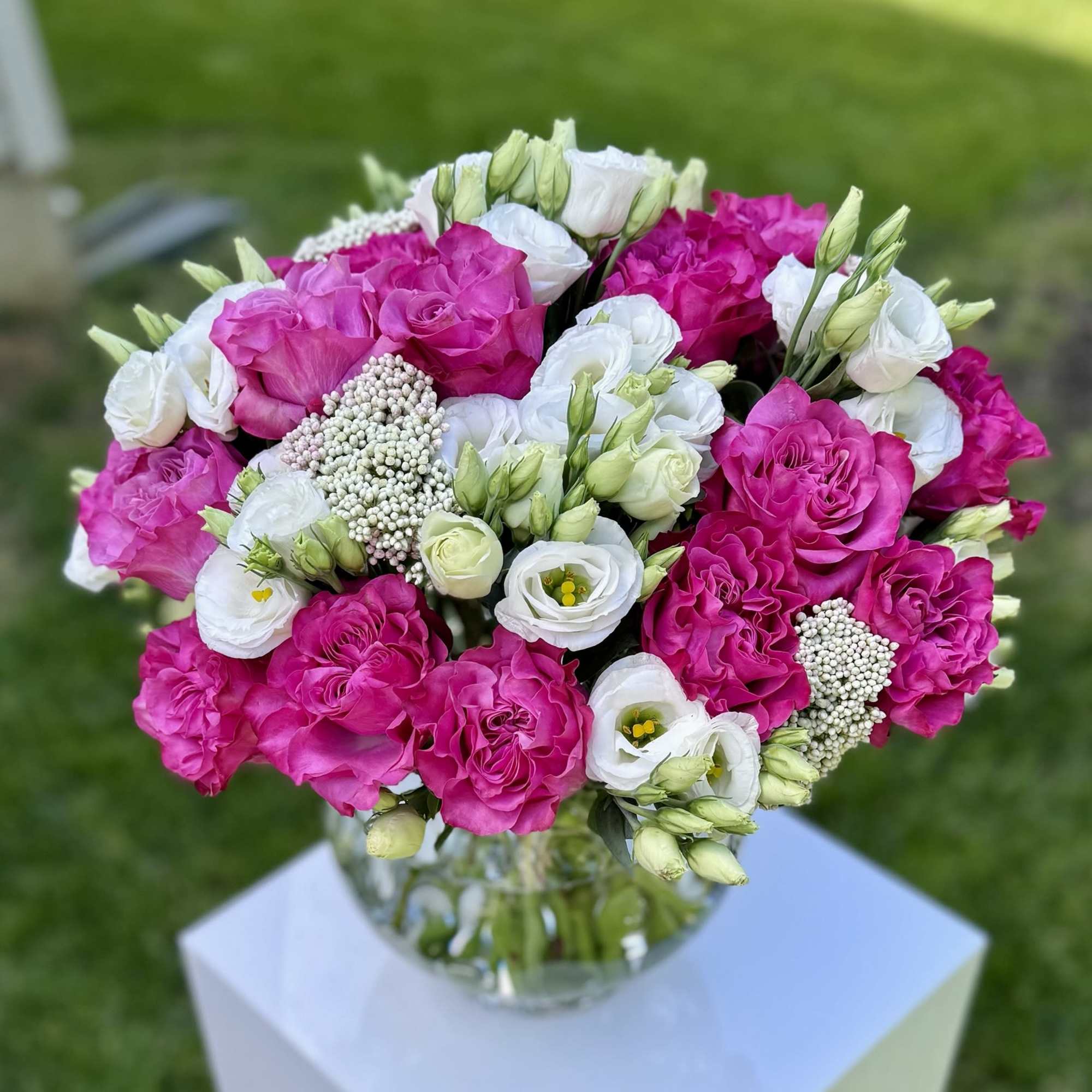 Pink and white roses with white lisianthus in a glass vase