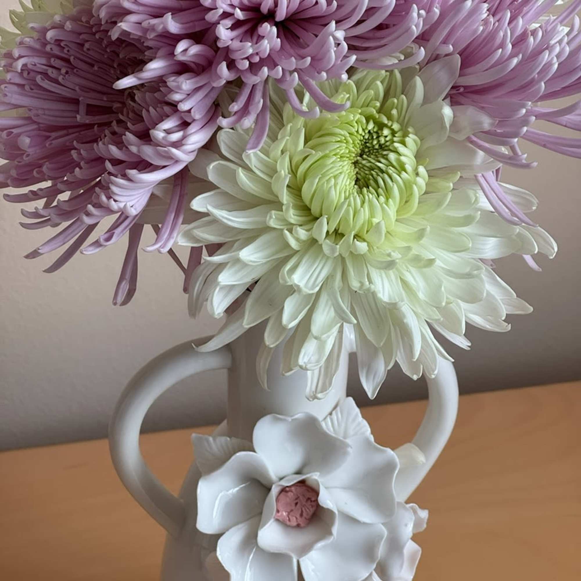 Bouquet of lavender and white chrysanthemums in a white pitcher vase