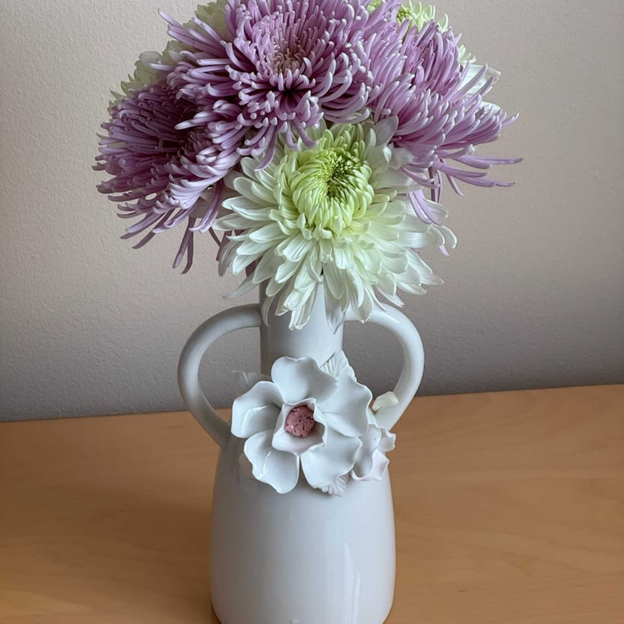 Lavender and white chrysanthemum bouquet in a white vase