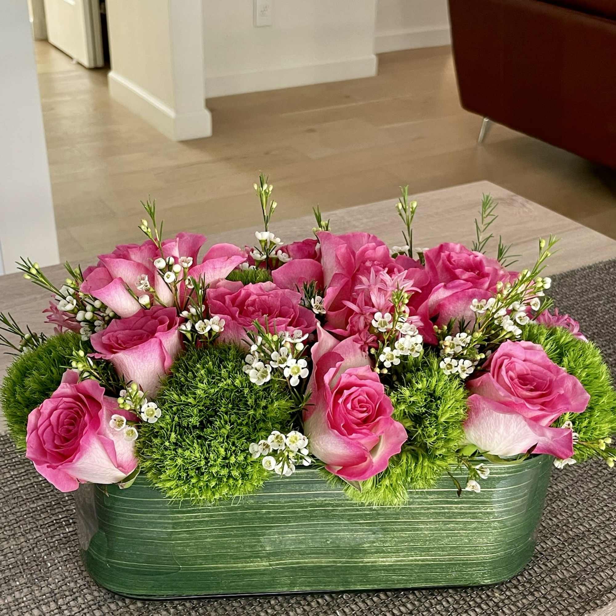 Pink roses and green moss in a rectangular green container