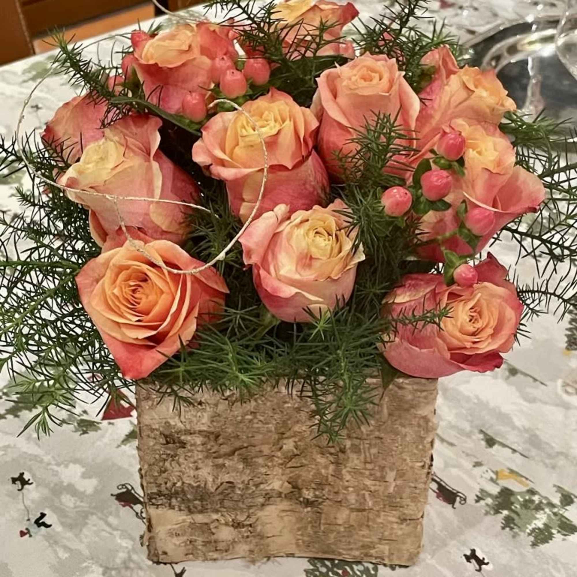 Pink and peach roses arranged in a birch bark container