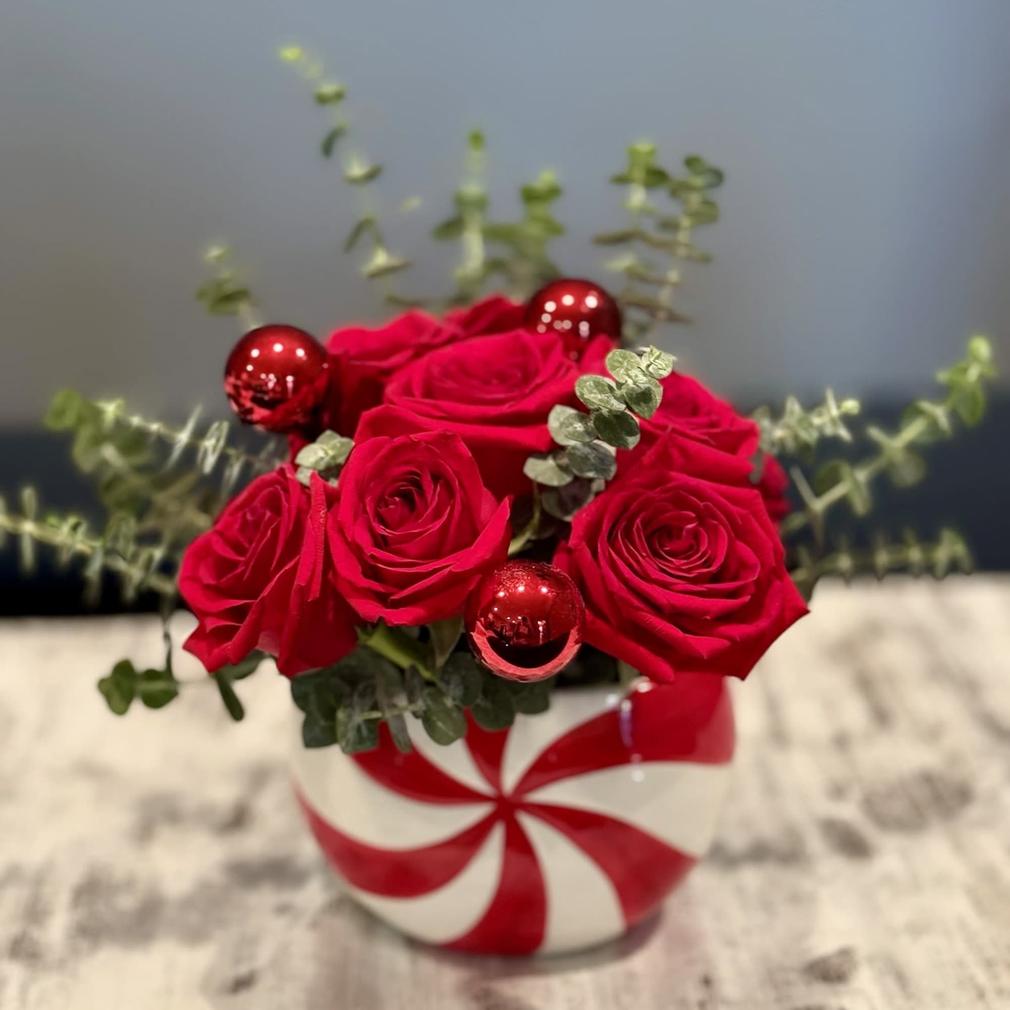 Red roses in a striped round vase with red ornaments