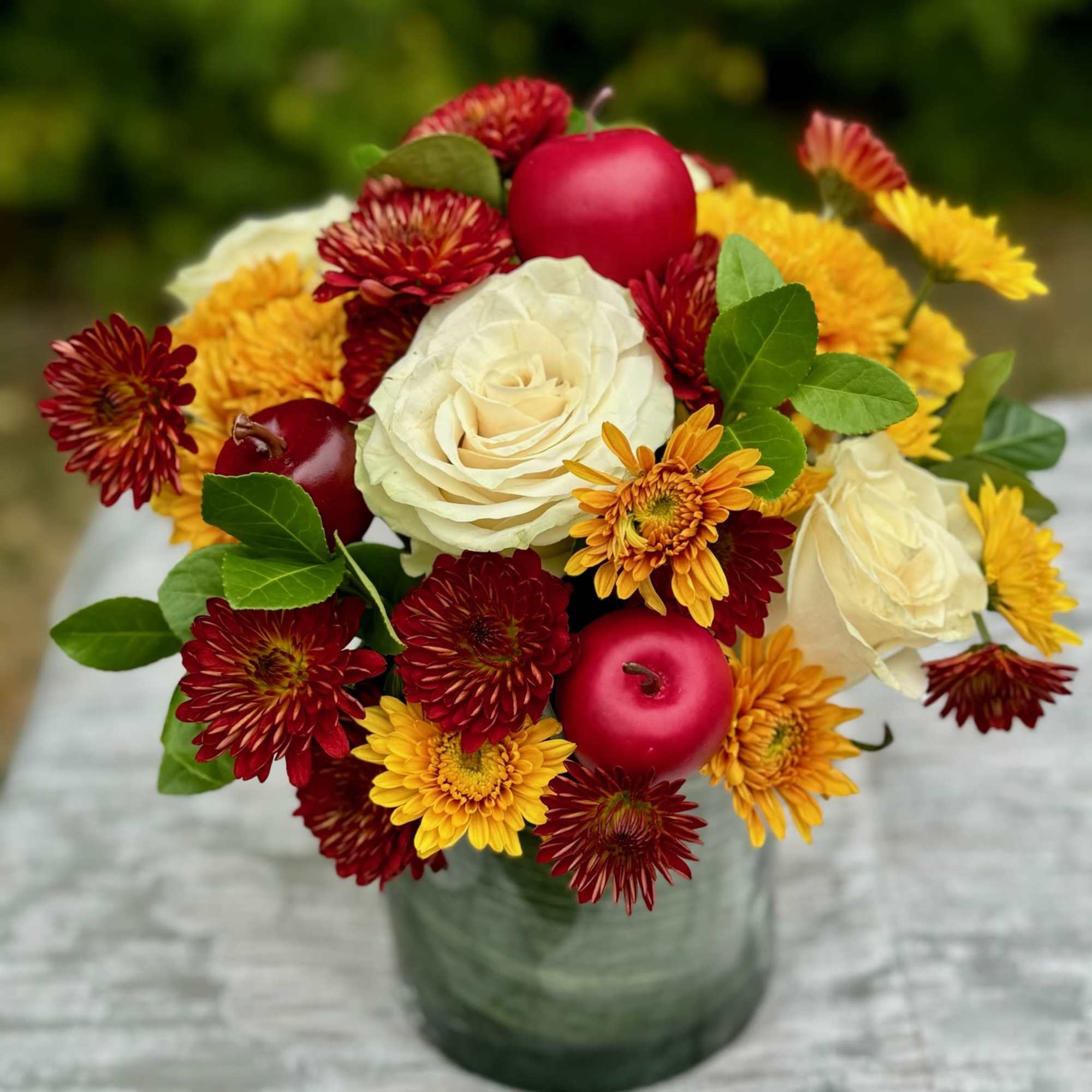 Bouquet of white roses and red-yellow chrysanthemums in a glass vase