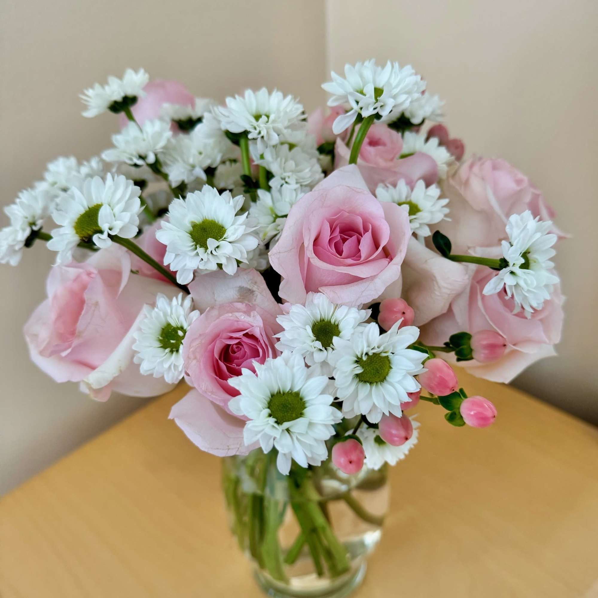Pink roses and white daisies arranged in a clear glass vase, photo 2 of 4