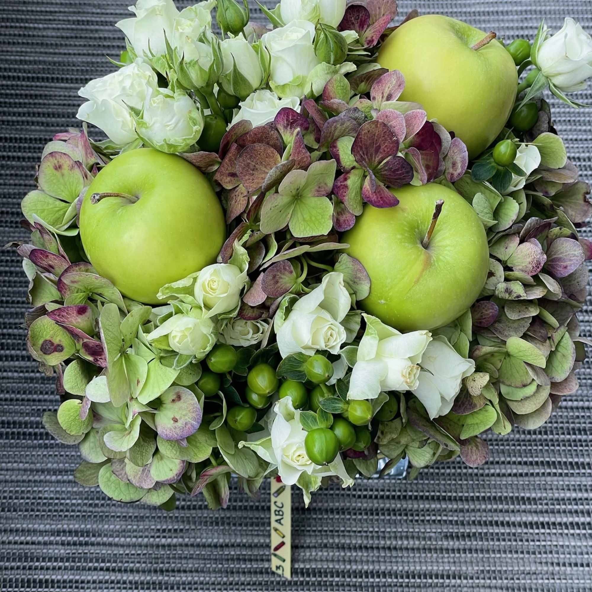 Round bouquet of white roses, hydrangea, and green apples