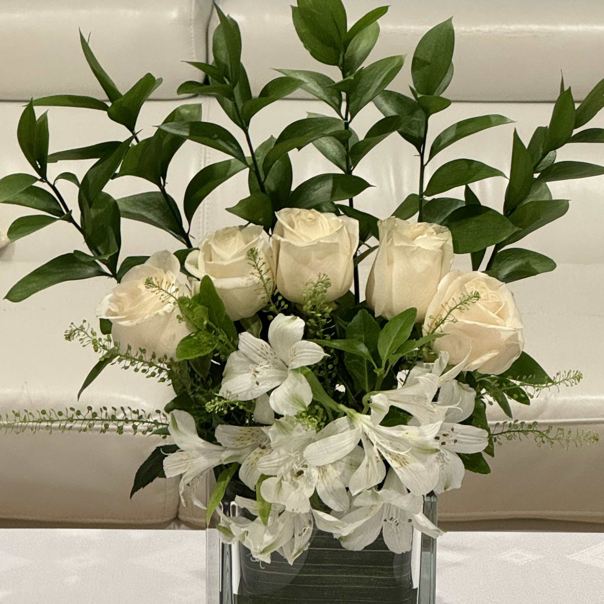 White roses and lilies in a clear glass vase