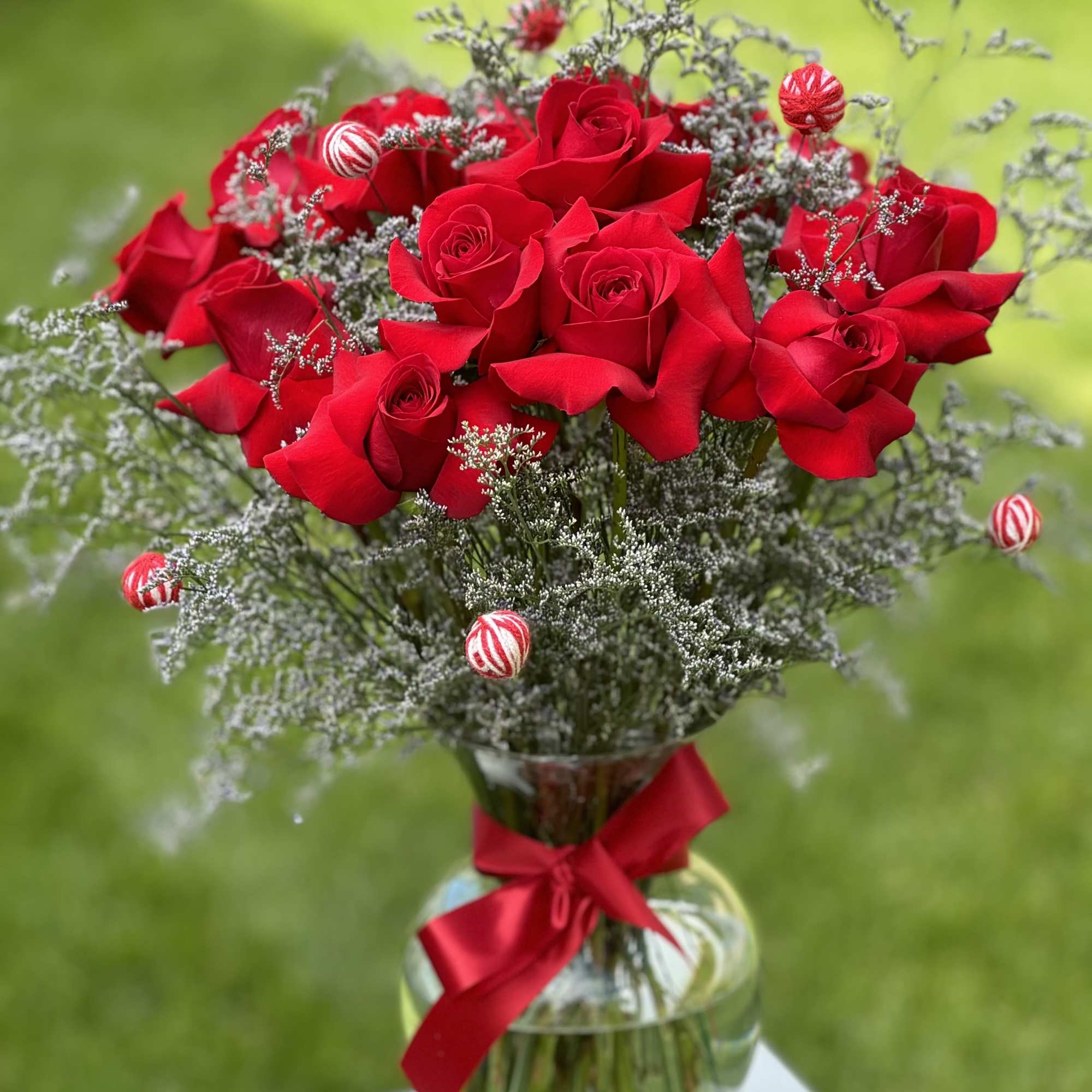 Bouquet of red roses in a glass vase with a red ribbon
