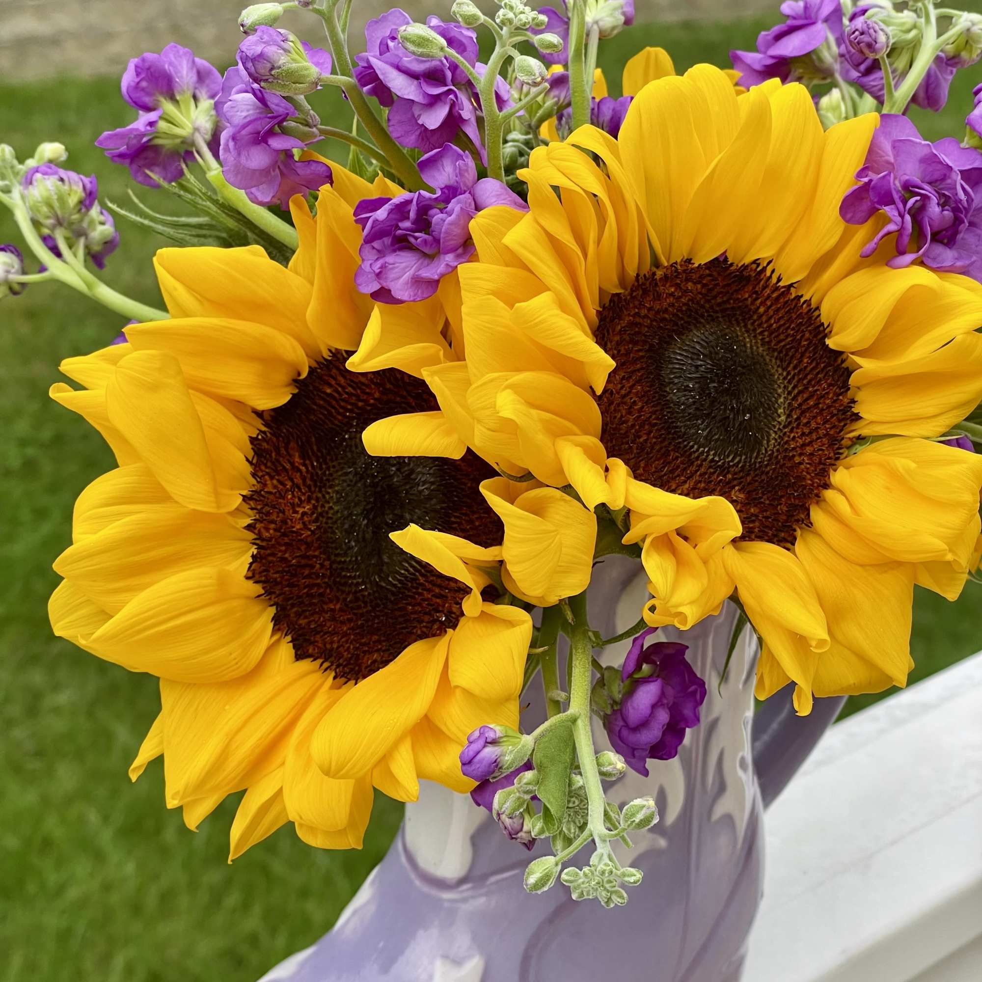 Bouquet of yellow sunflowers and purple flowers in a lavender boot vase, photo 4 of 5
