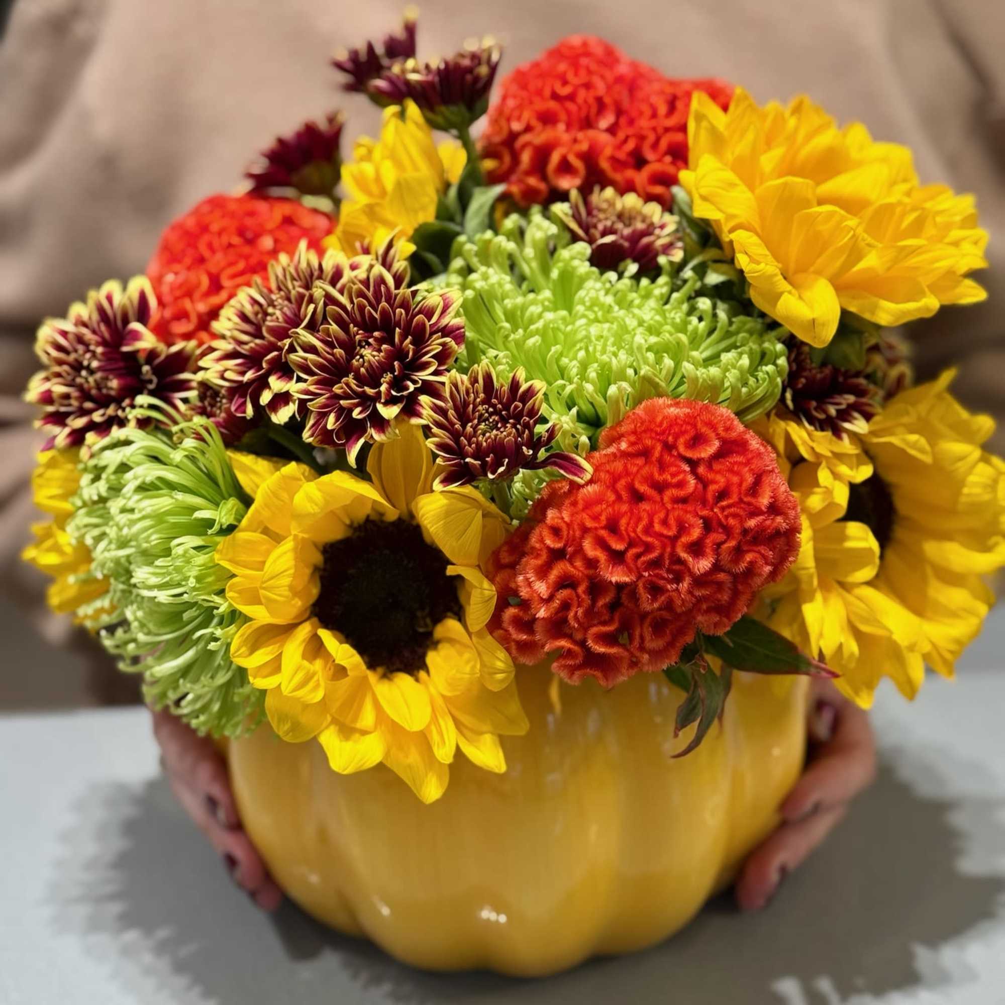 Mixed bouquet in a yellow pumpkin vase with sunflowers and chrysanthemums