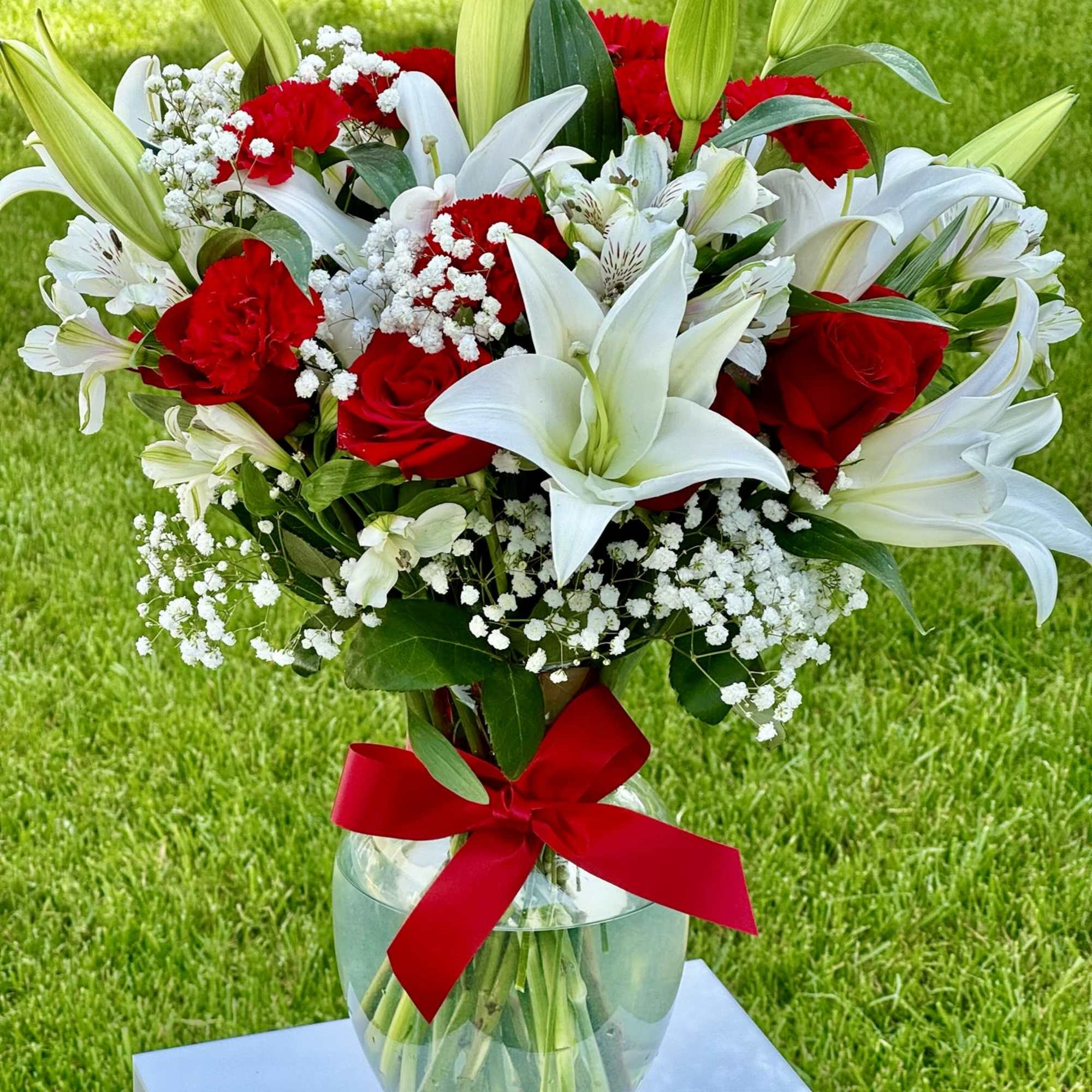 Bouquet of red roses and white lilies in a glass vase with a red ribbon, photo 2 of 3