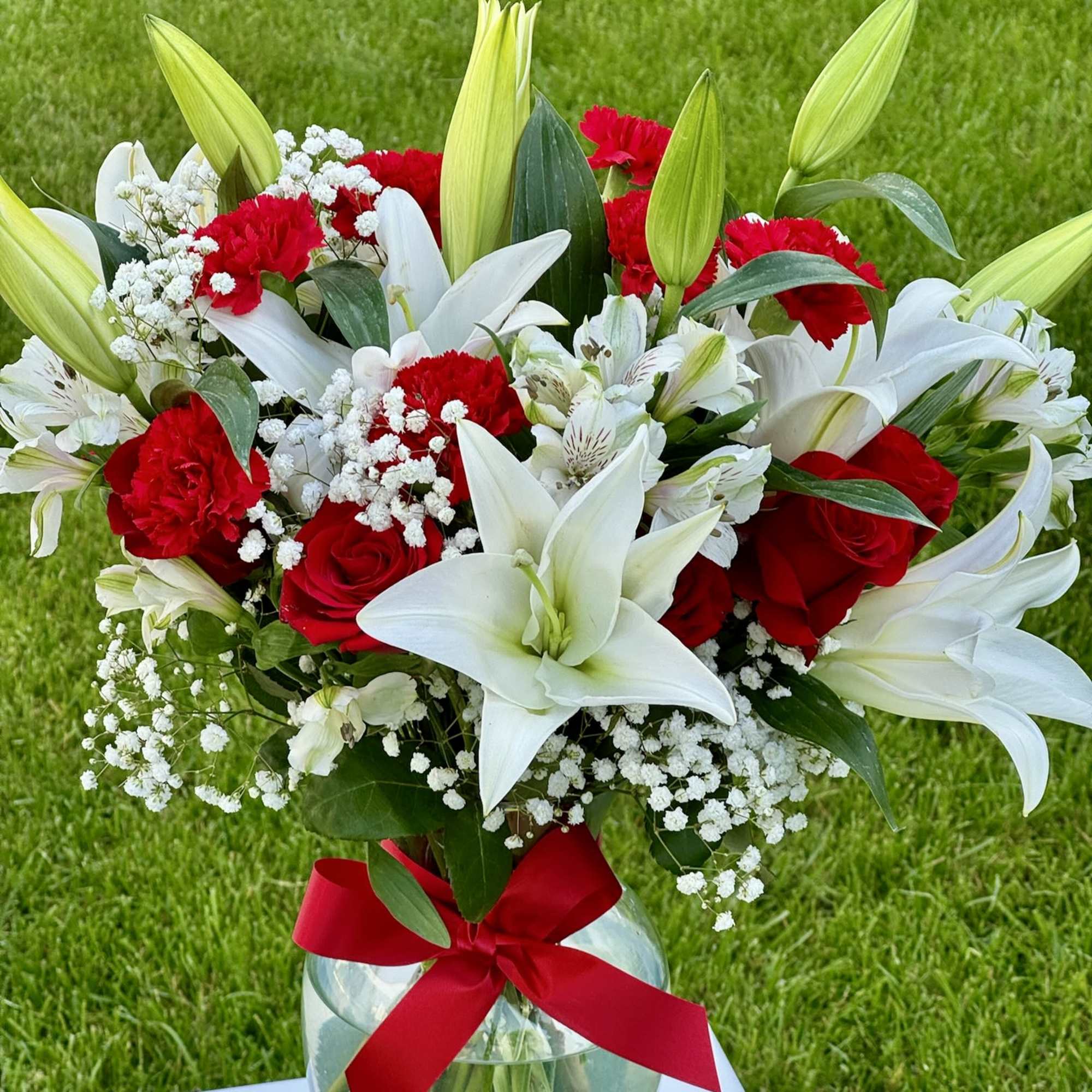 Bouquet of red roses and white lilies in a glass vase with a red ribbon, photo 3 of 3