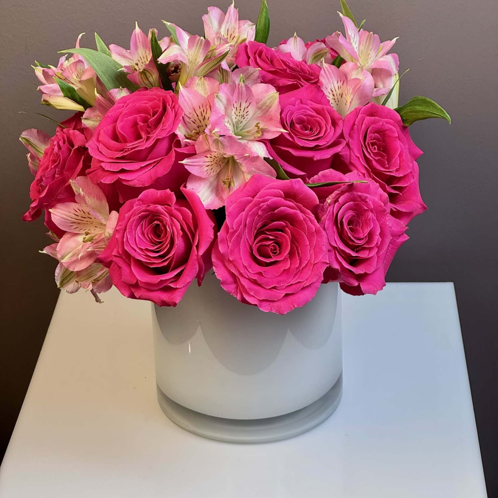 Pink roses and pale pink alstroemeria in a white vase