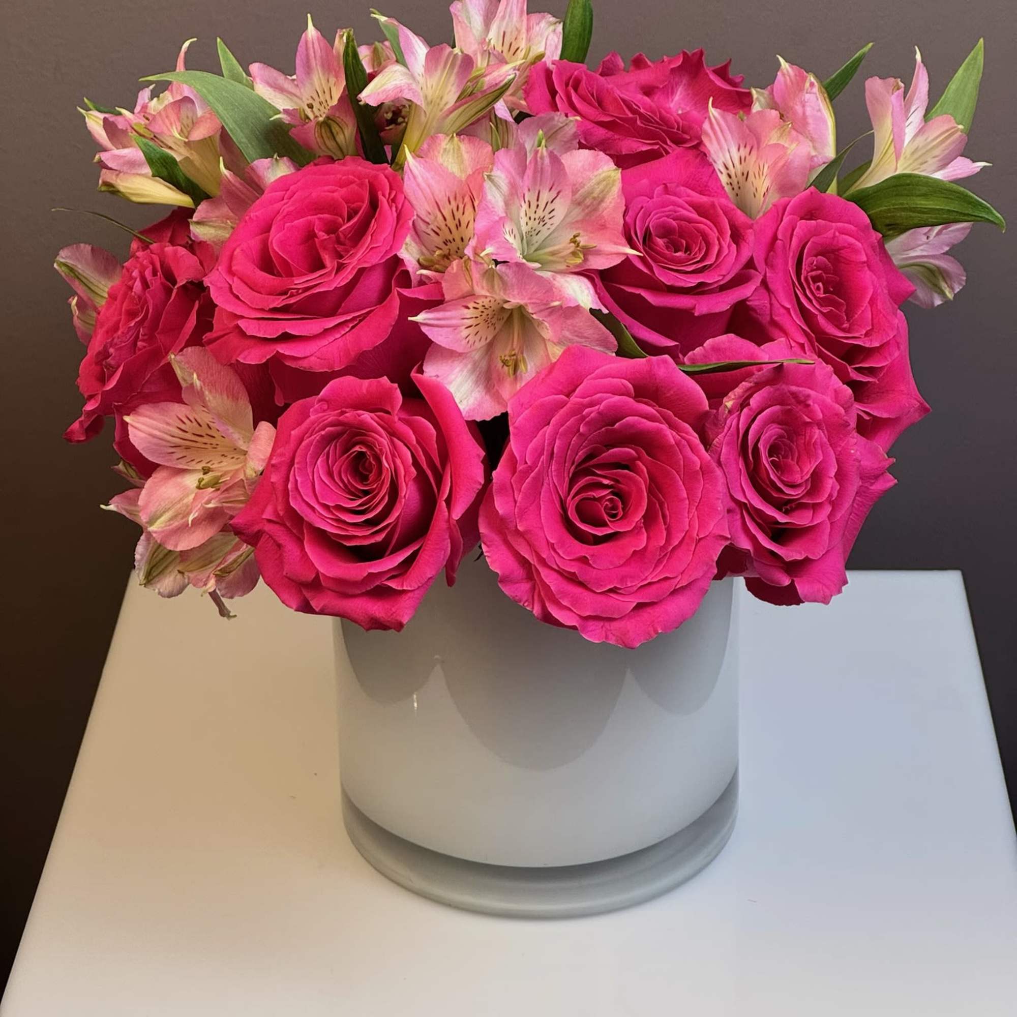 Pink roses and alstroemeria arranged in a white vase