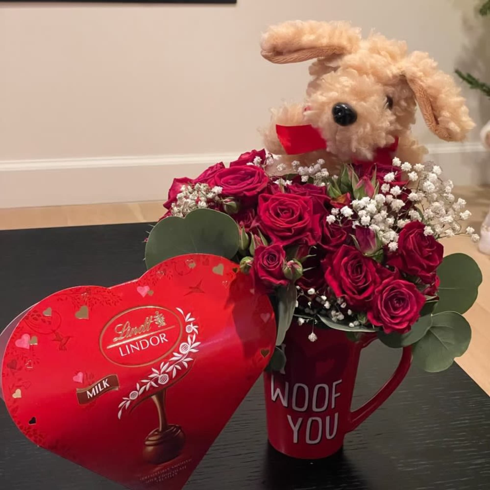 Red rose bouquet in a mug with a plush dog and heart-shaped chocolate box