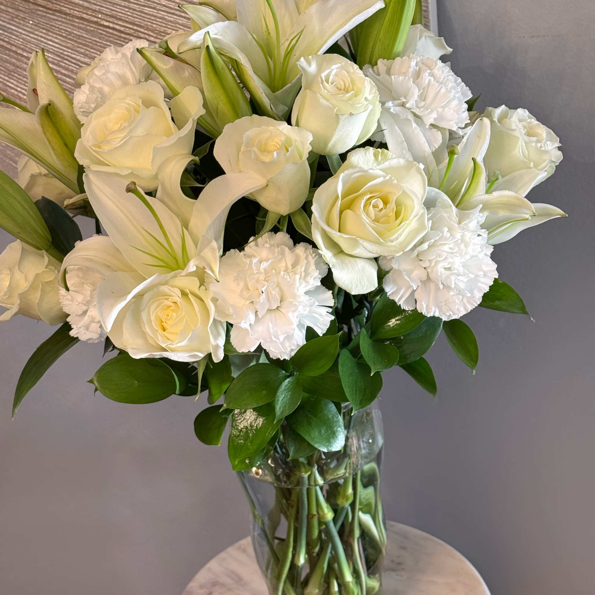 This timeless floral arrangement features a luxurious blend of pure white roses