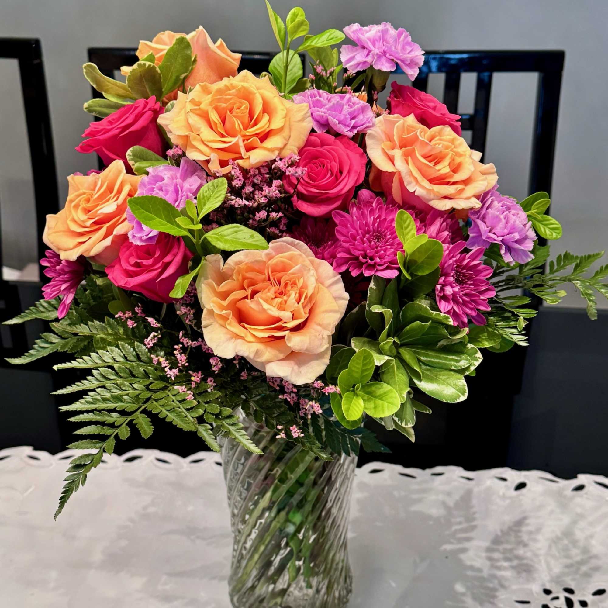 Mixed bouquet of peach and pink roses in a glass vase
