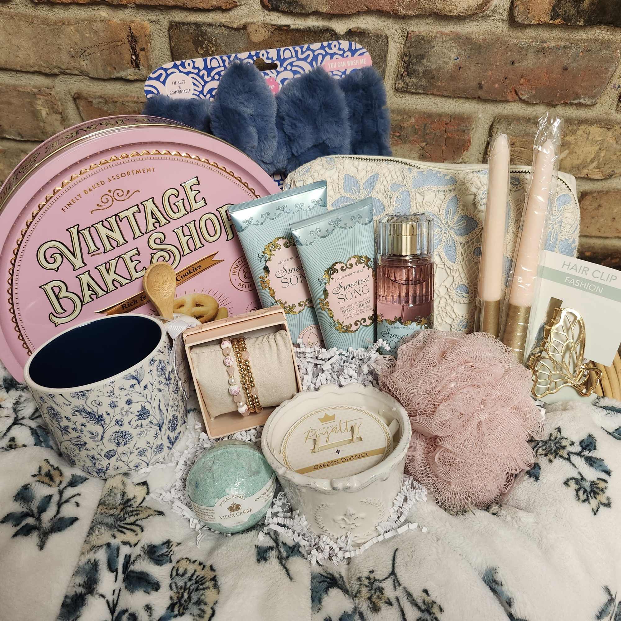 Gift basket with cookies, candles, lotion, mug, and hair accessories