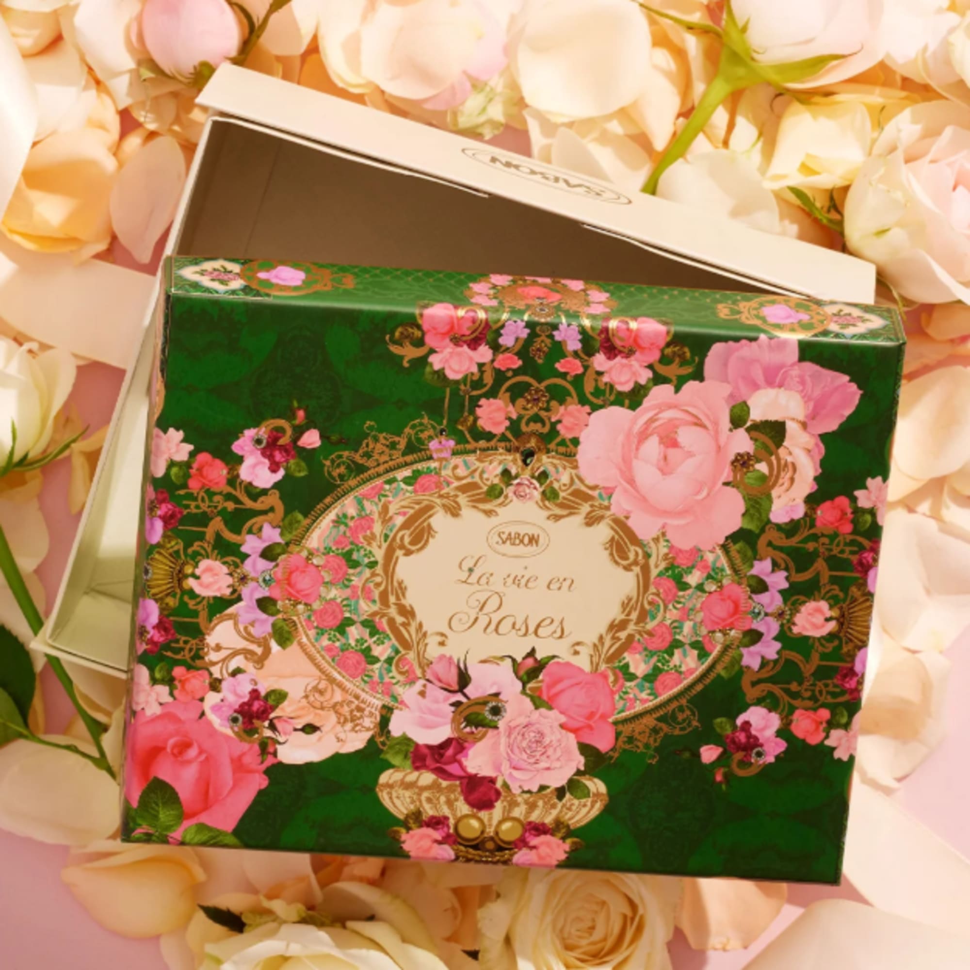 Floral-patterned gift box with pink roses on a bed of pale roses