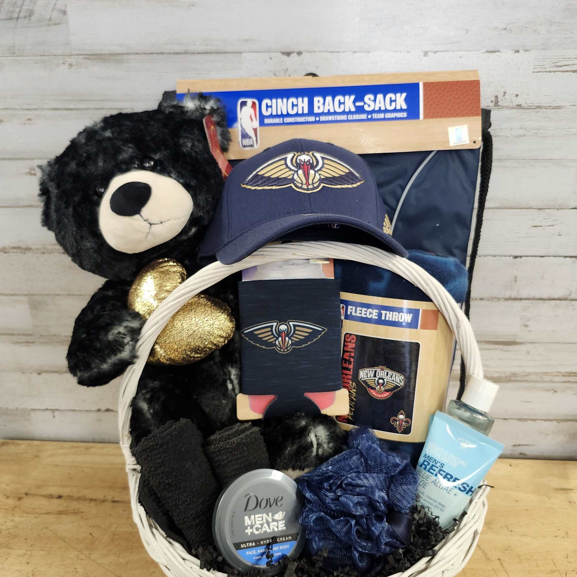 Gift basket with a teddy bear, sports items, and grooming products