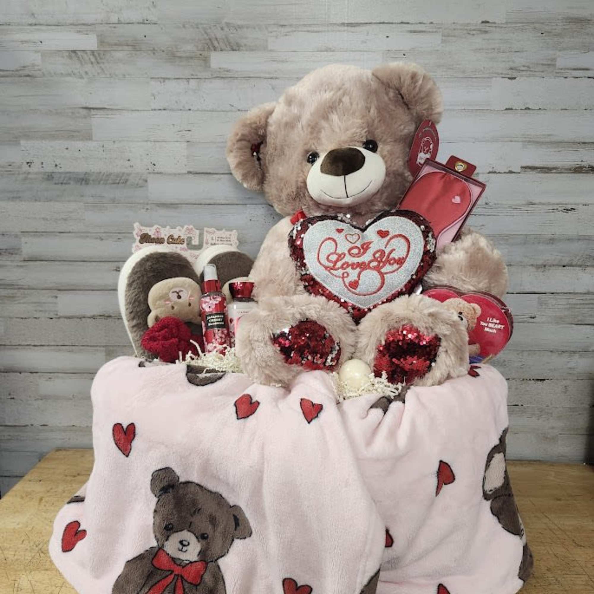 Teddy bear gift set with a heart pillow and small boxed items