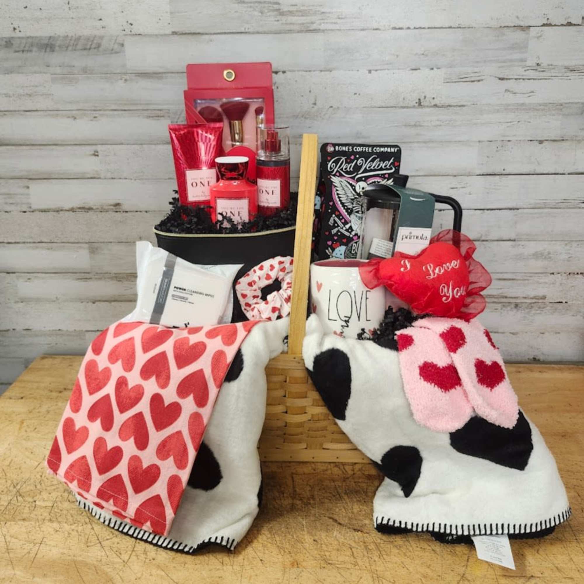 Gift basket with candles, coffee, and heart-patterned blankets