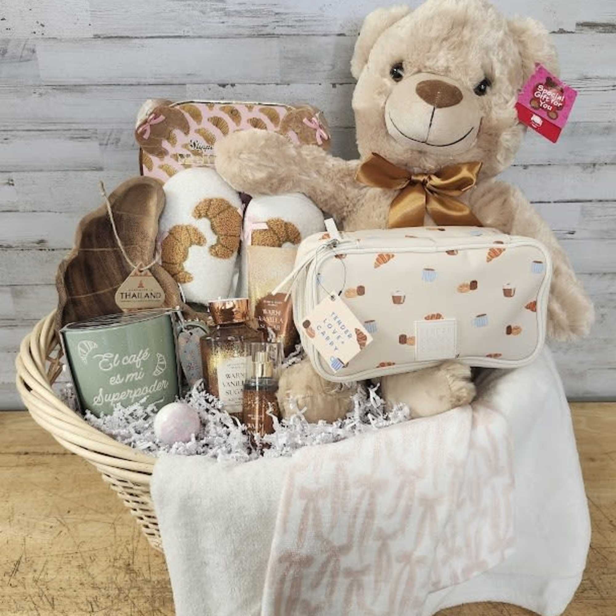 Gift basket with a teddy bear, candles, and a toiletry pouch