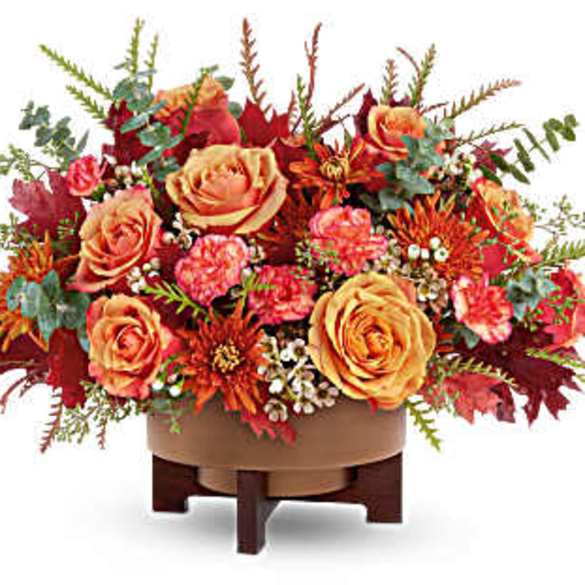 Autumn floral arrangement with orange roses in a low container