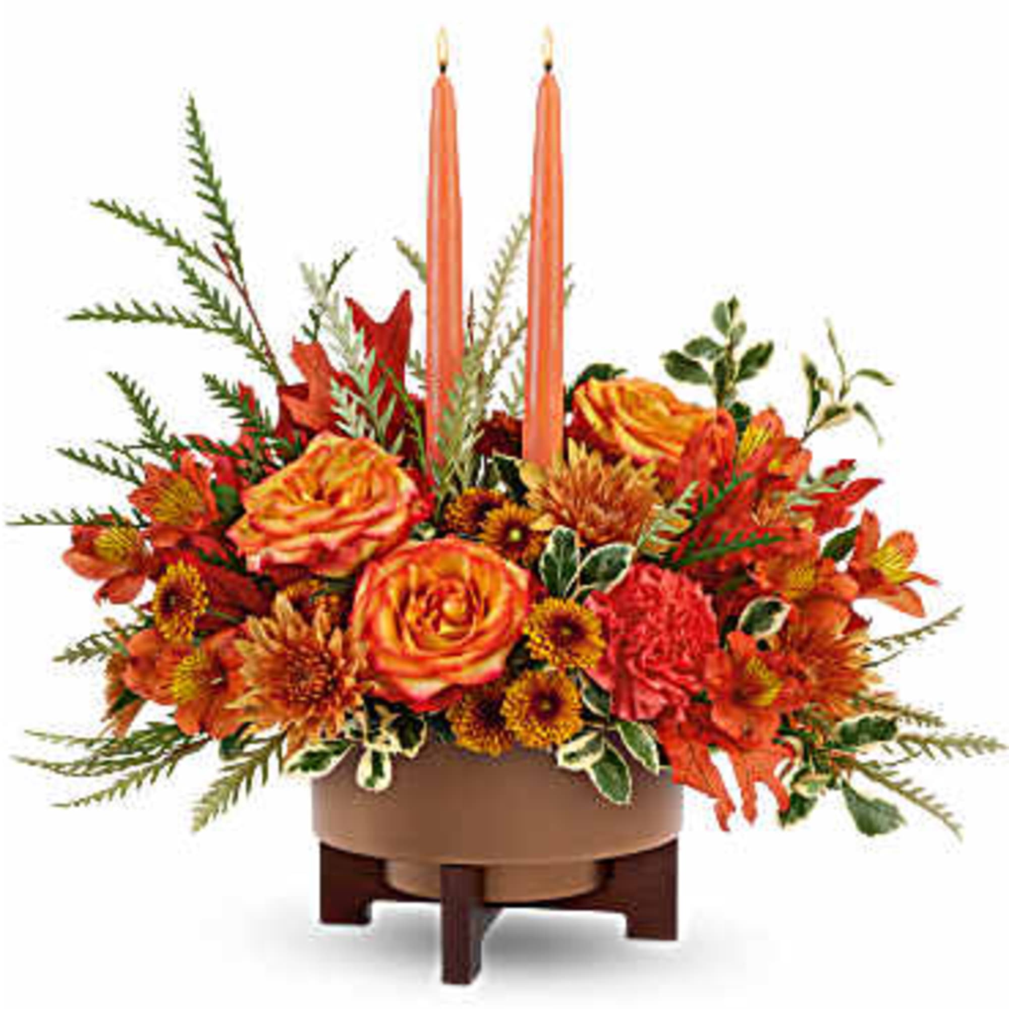 Orange floral centerpiece with two tall taper candles in a low bowl