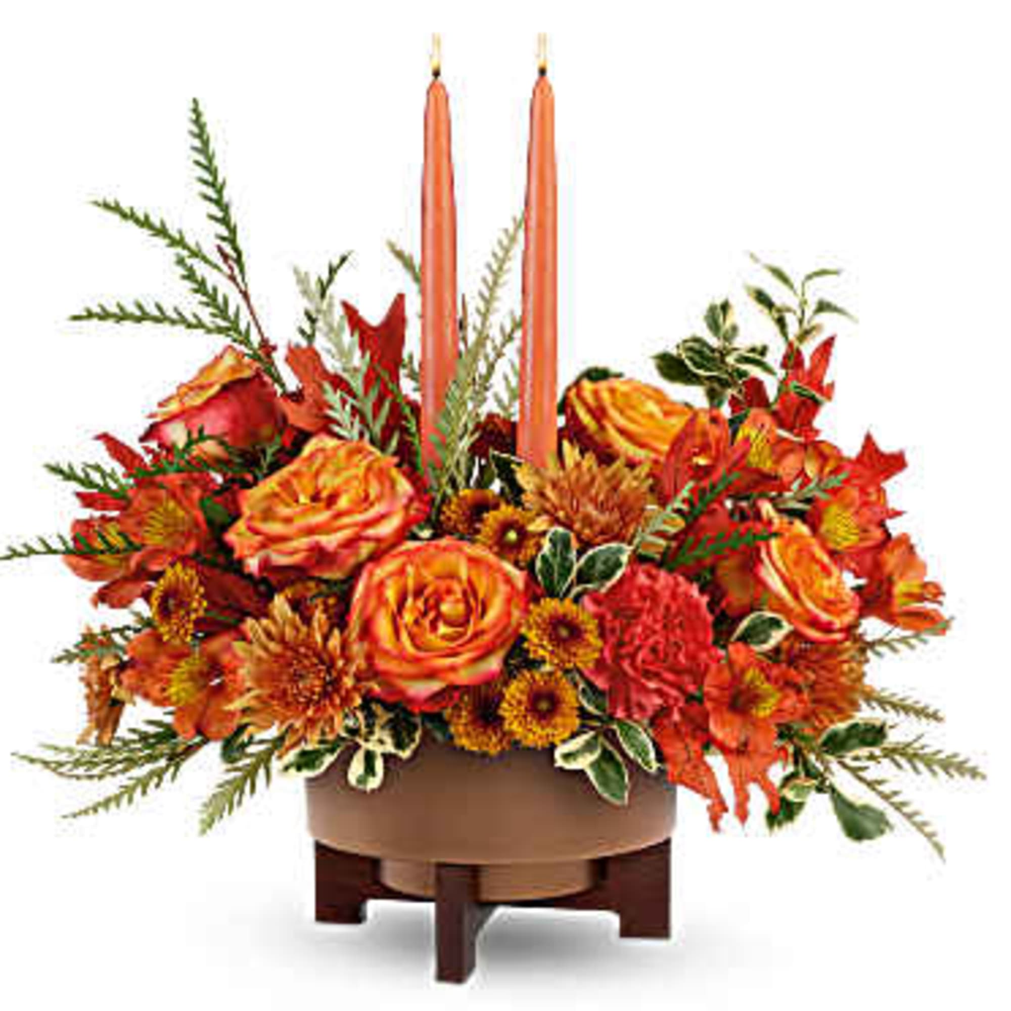 Orange floral centerpiece with two tall candles in a low round container