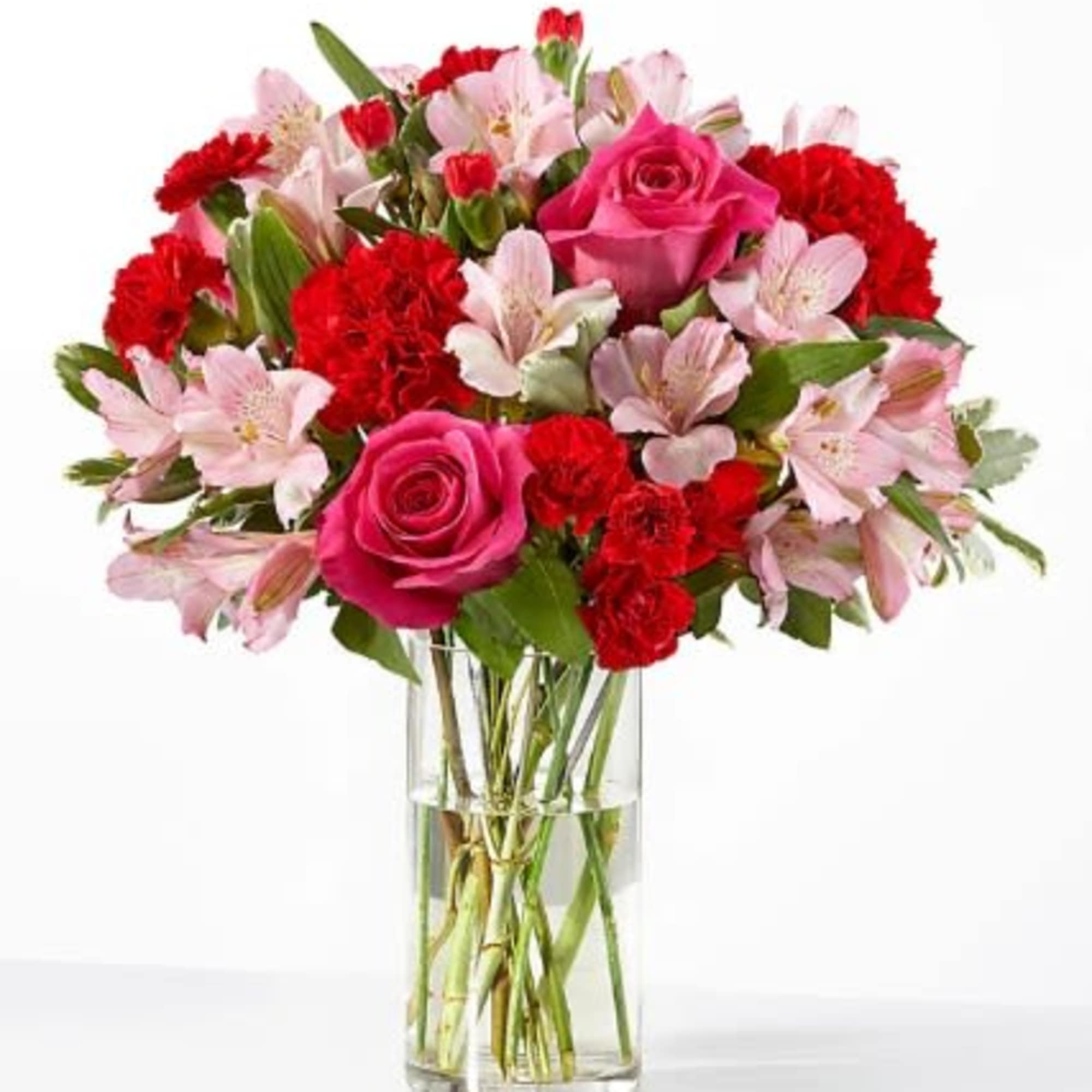 Pink roses, red carnations, and light pink alstroemeria in a clear glass vase