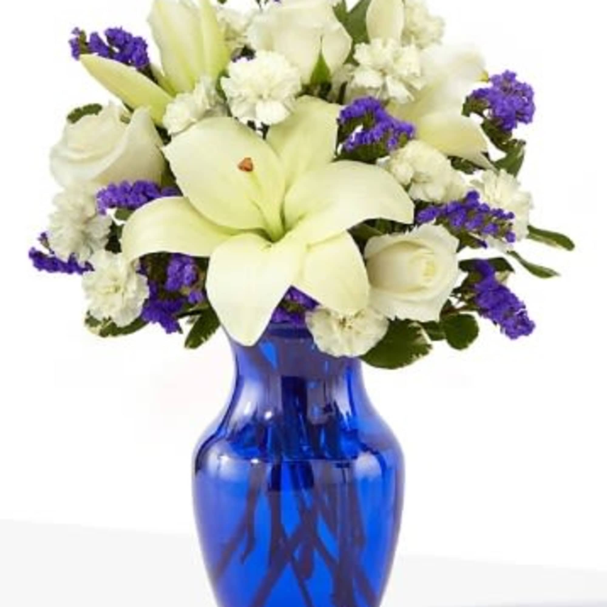 White lilies and roses in a blue glass vase with purple accents