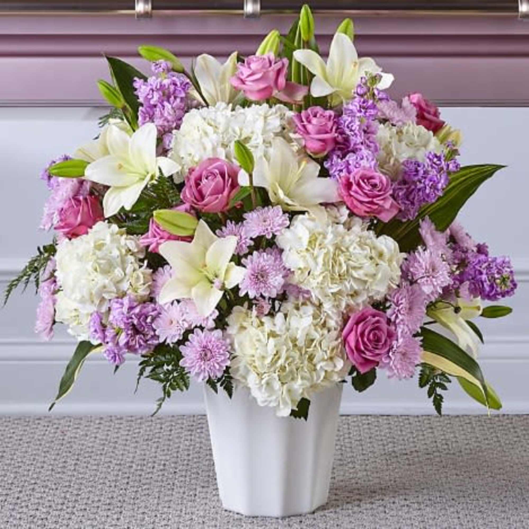 Pink roses and white lilies in a white vase