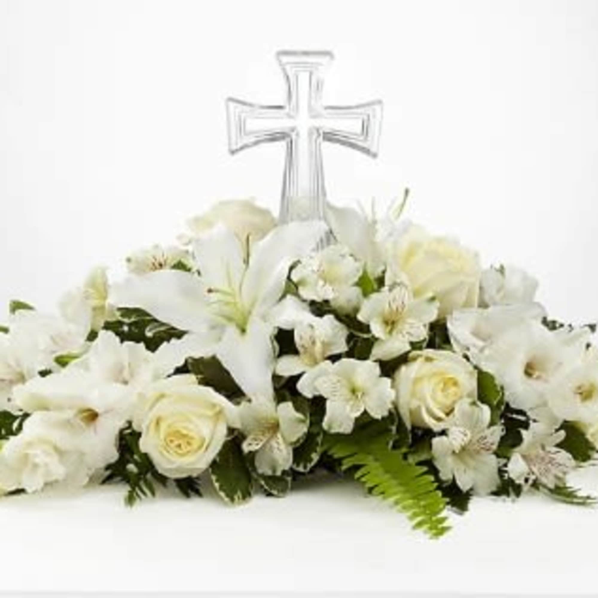 White floral casket spray with a clear cross topper