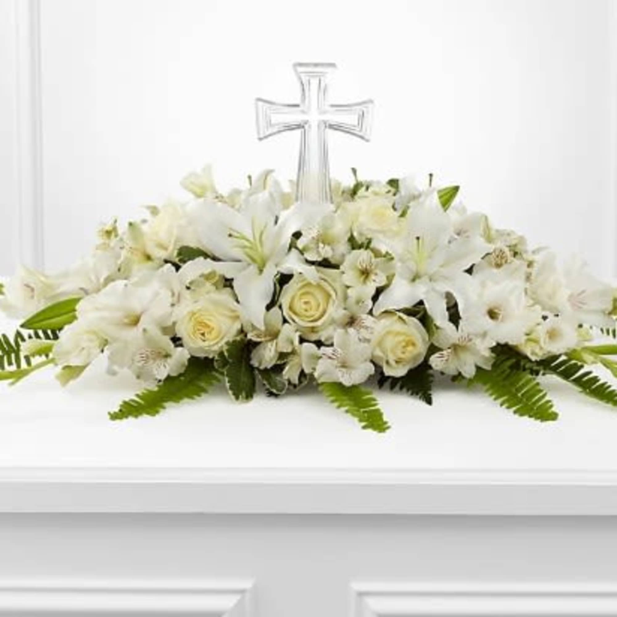 White floral arrangement with a clear cross centerpiece