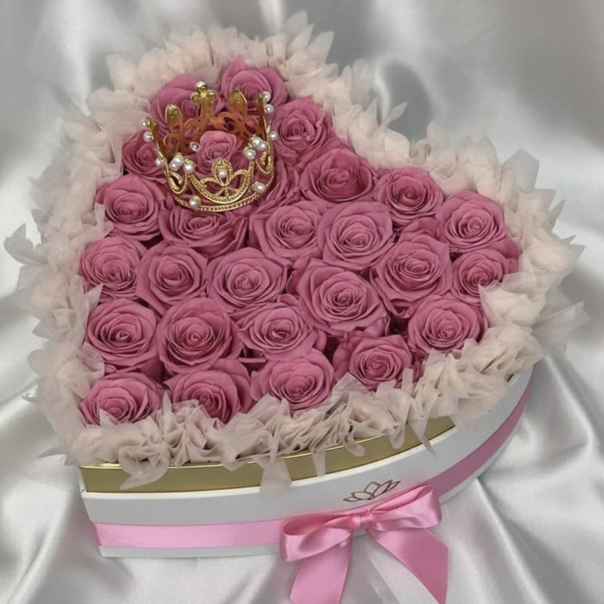 Heart-shaped box of pink roses with a small crown topper