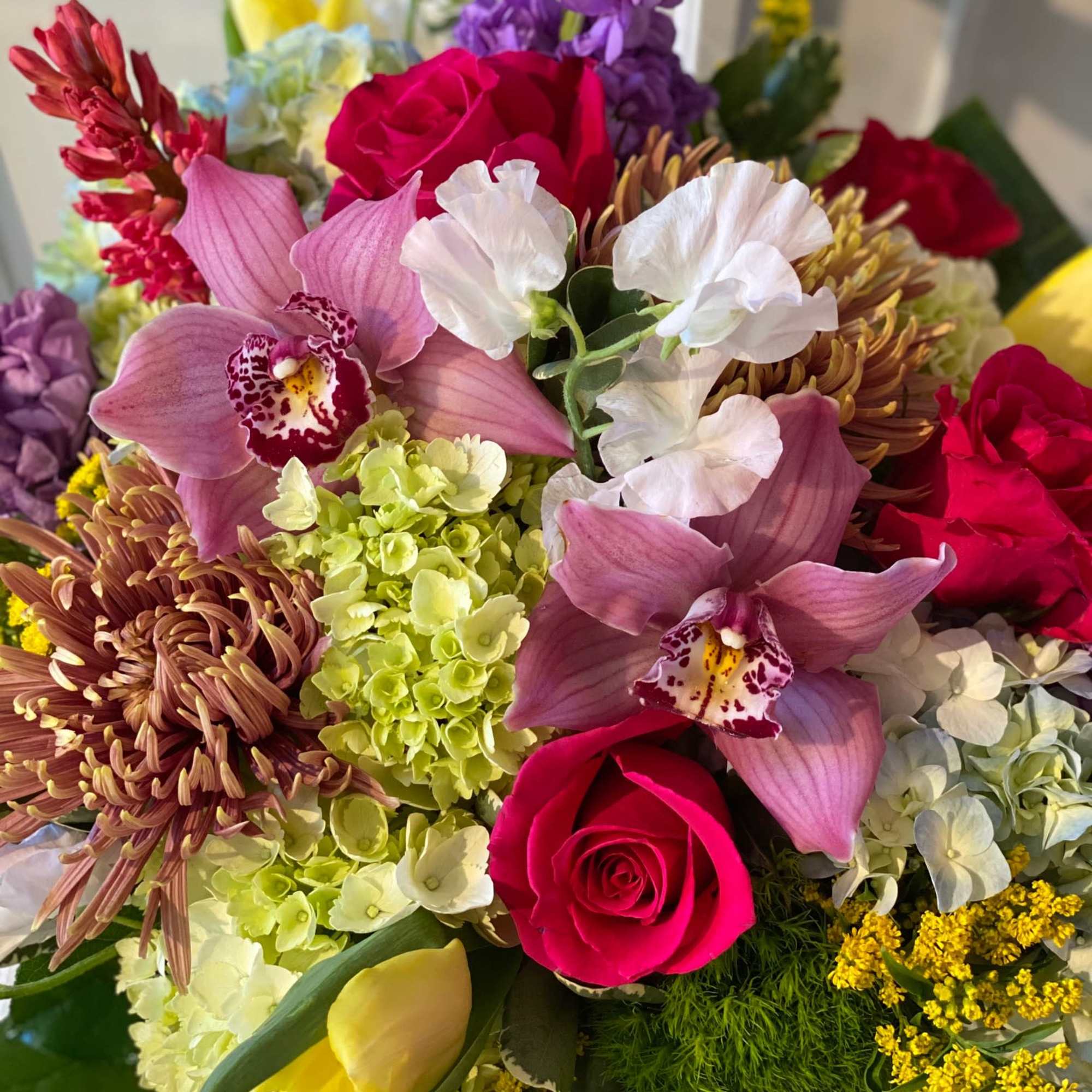 Mixed bouquet with pink roses, orchids, hydrangeas, and yellow tulips