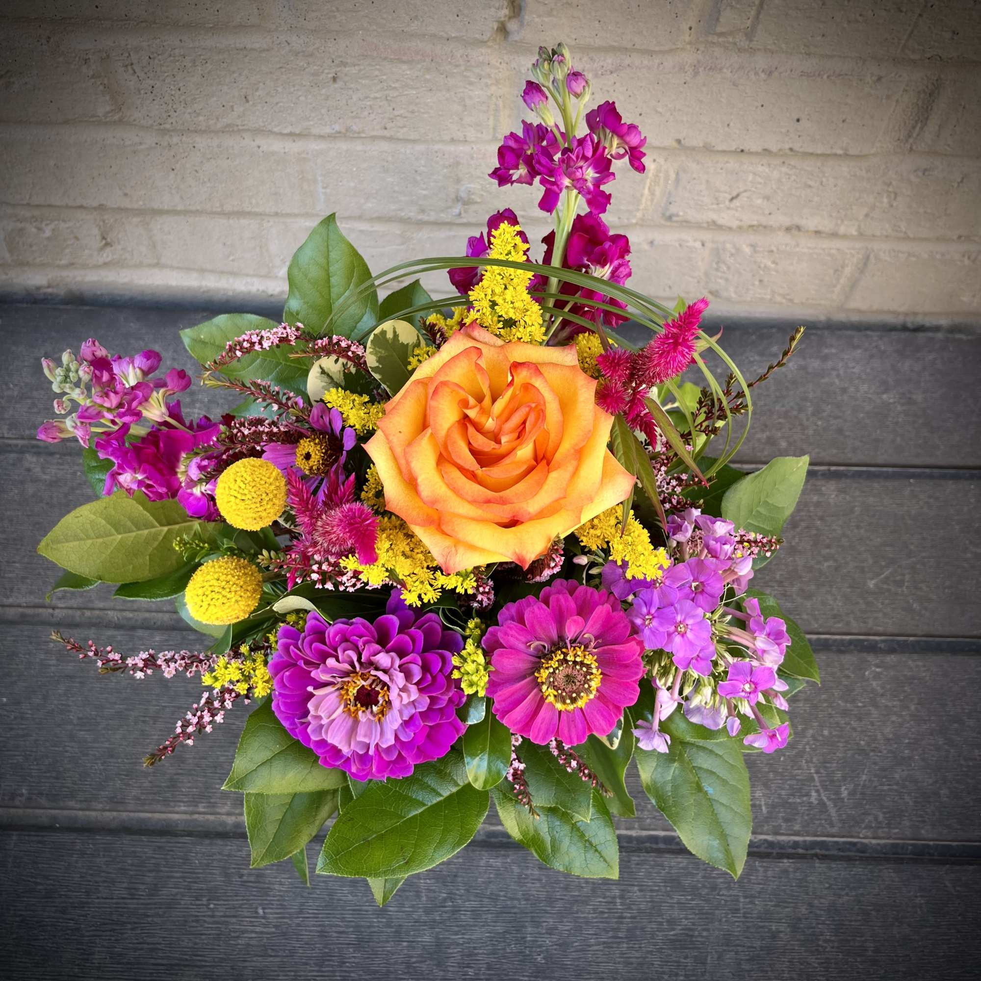 Bright mixed bouquet with an orange rose and magenta flowers