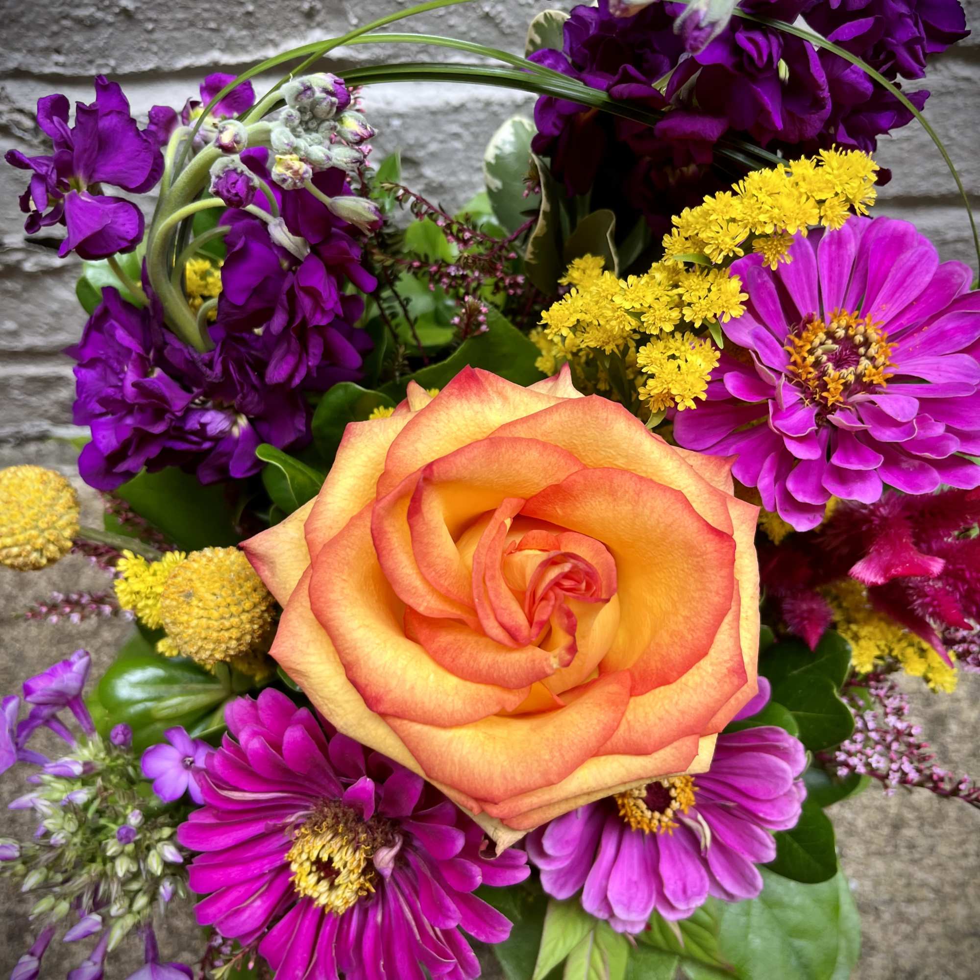 Bouquet with an orange rose and purple flowers