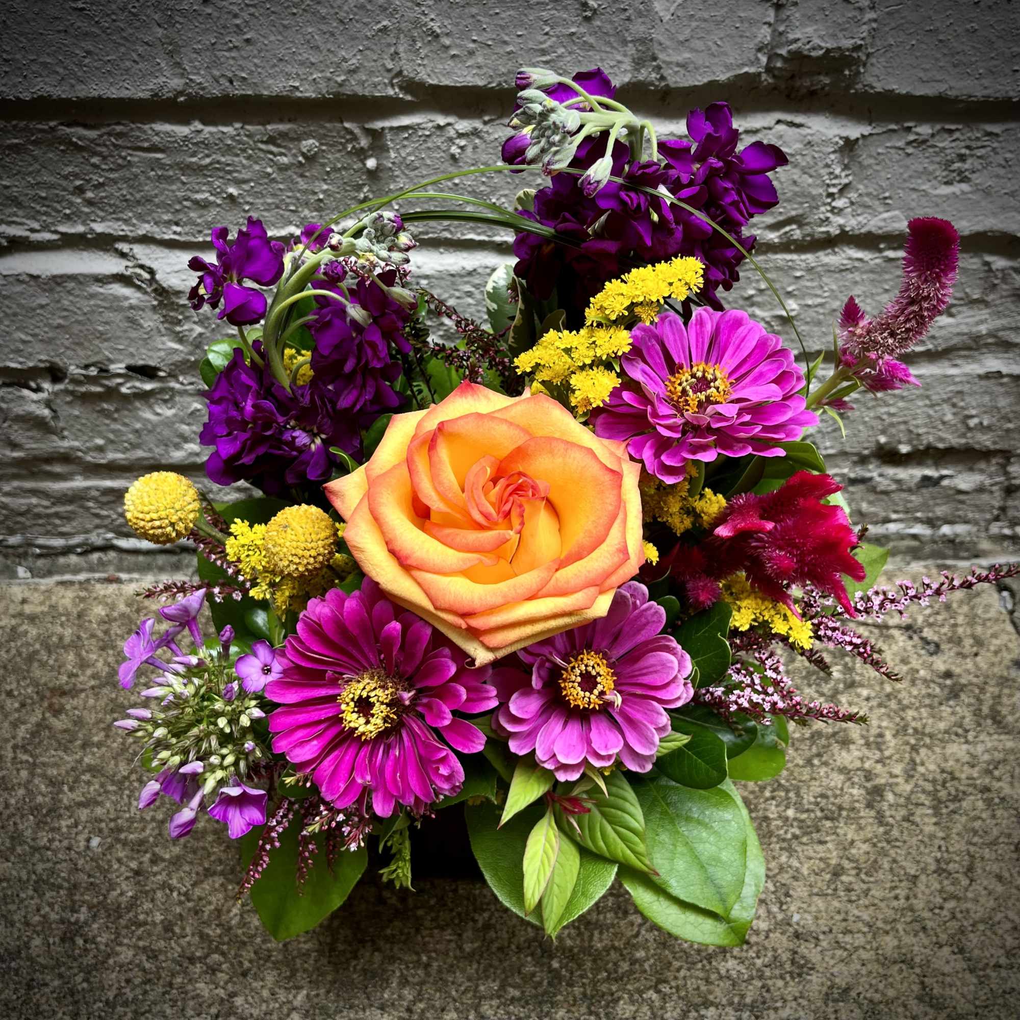 Mixed bouquet with an orange rose and bright pink flowers