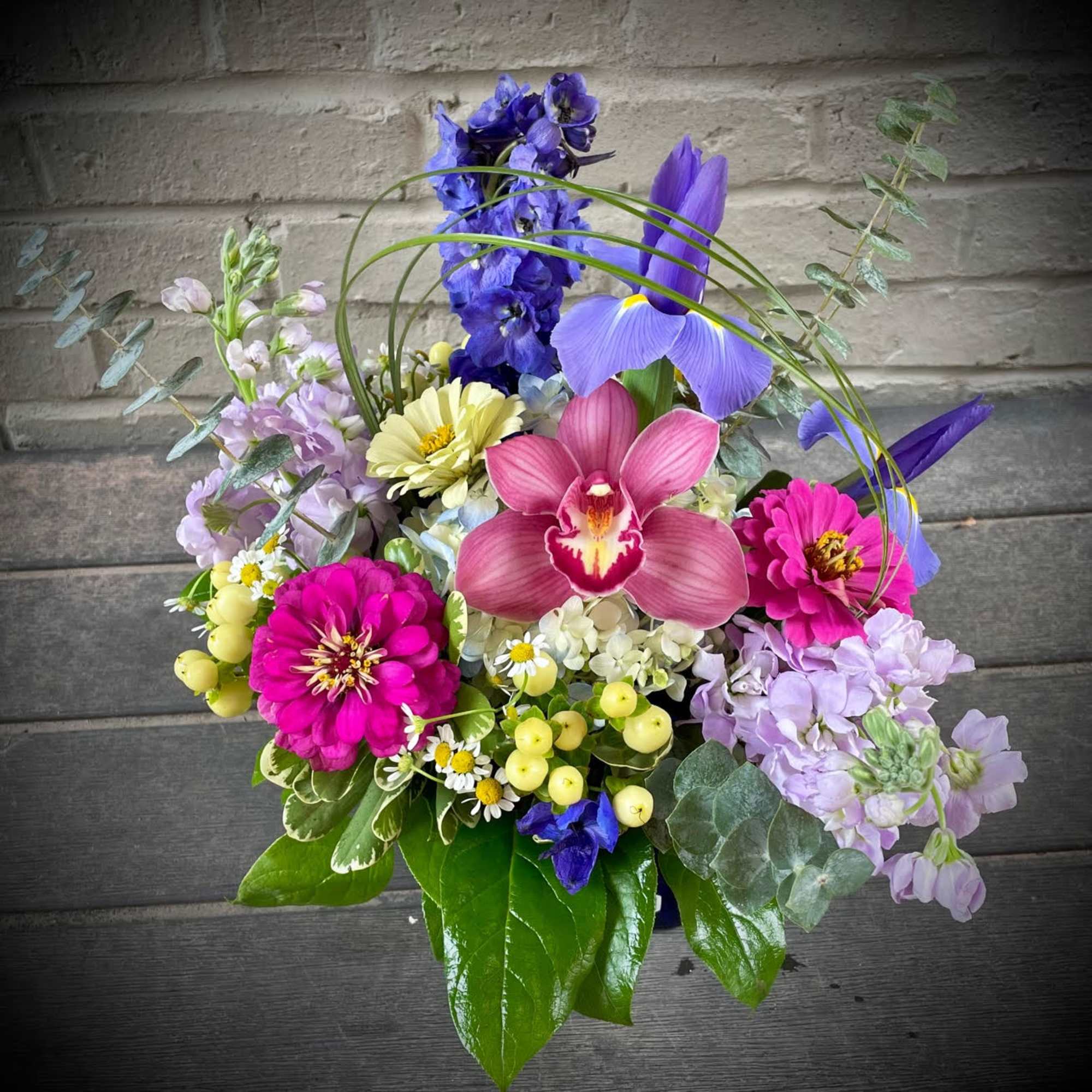 Colorful bouquet with orchids, zinnias, and mixed blooms