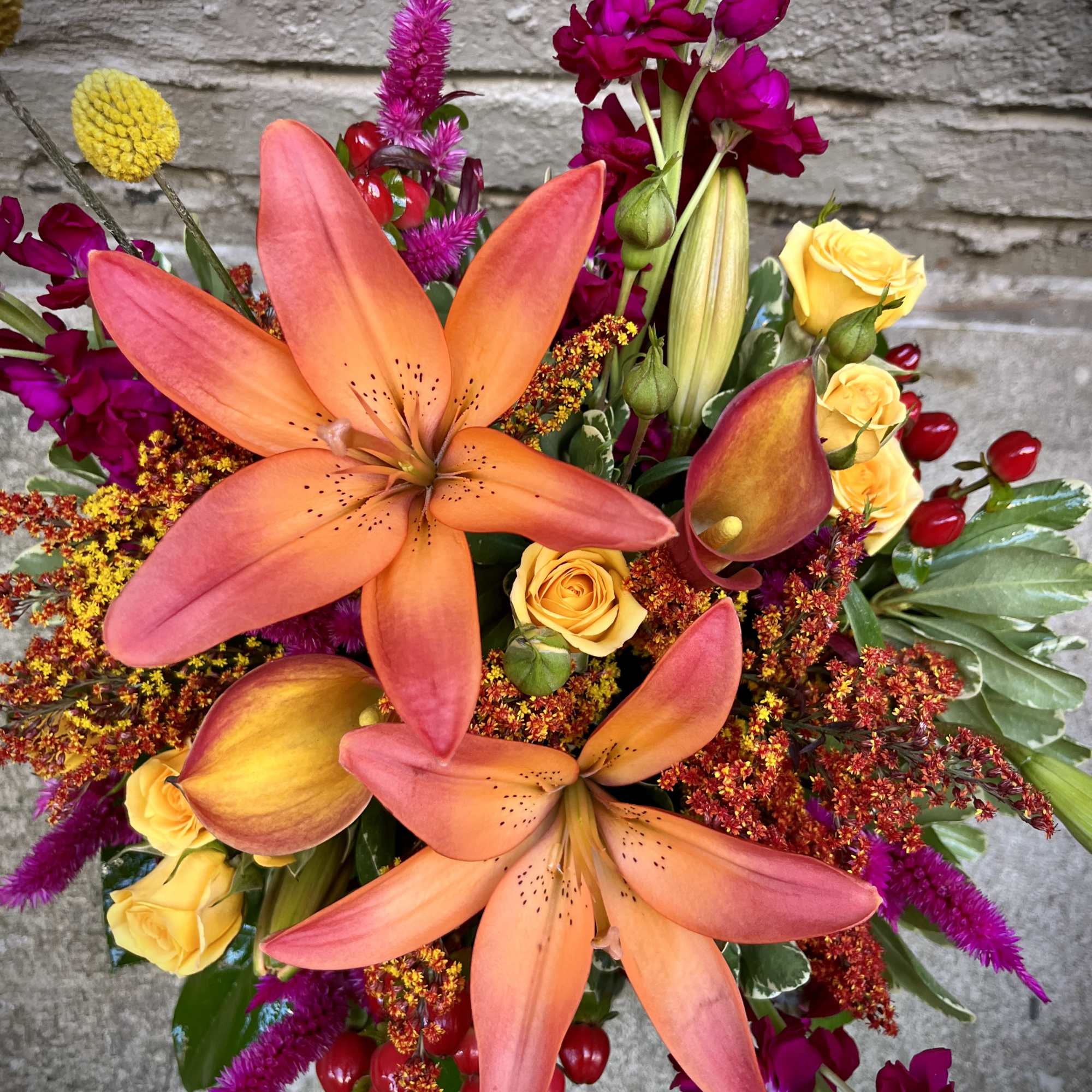Bouquet with orange lilies, yellow roses, and magenta flowers